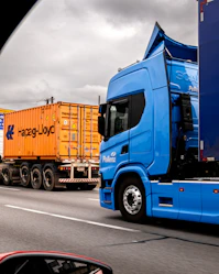 Two trucks on a highway under cloudy sky