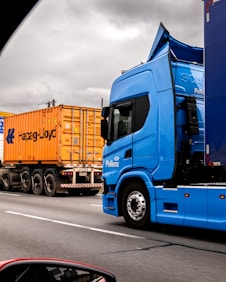 Two trucks on a highway under cloudy sky