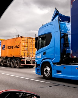 Two trucks on a highway under cloudy sky
