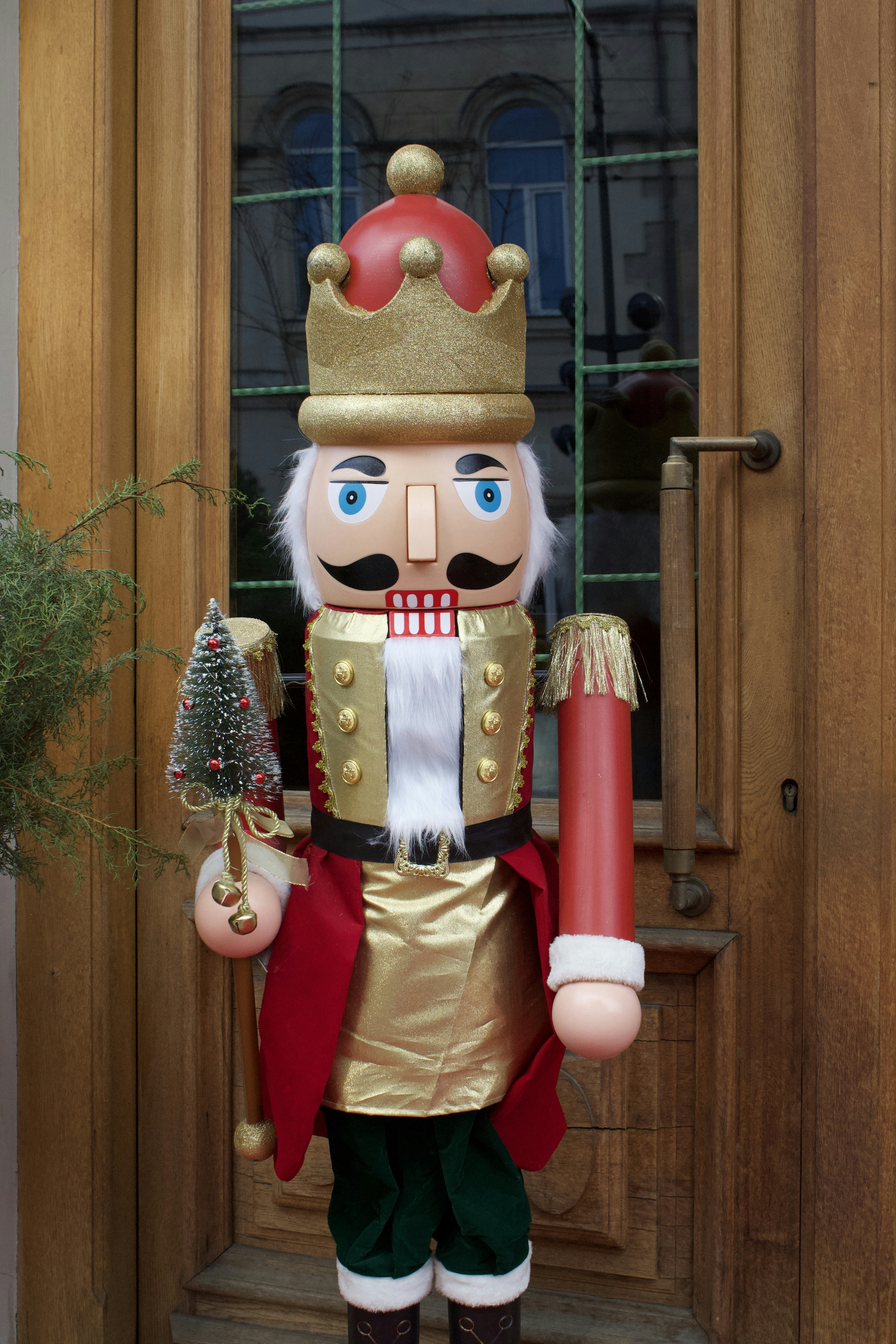 A large nutcracker decoration holding a small christmas tree.