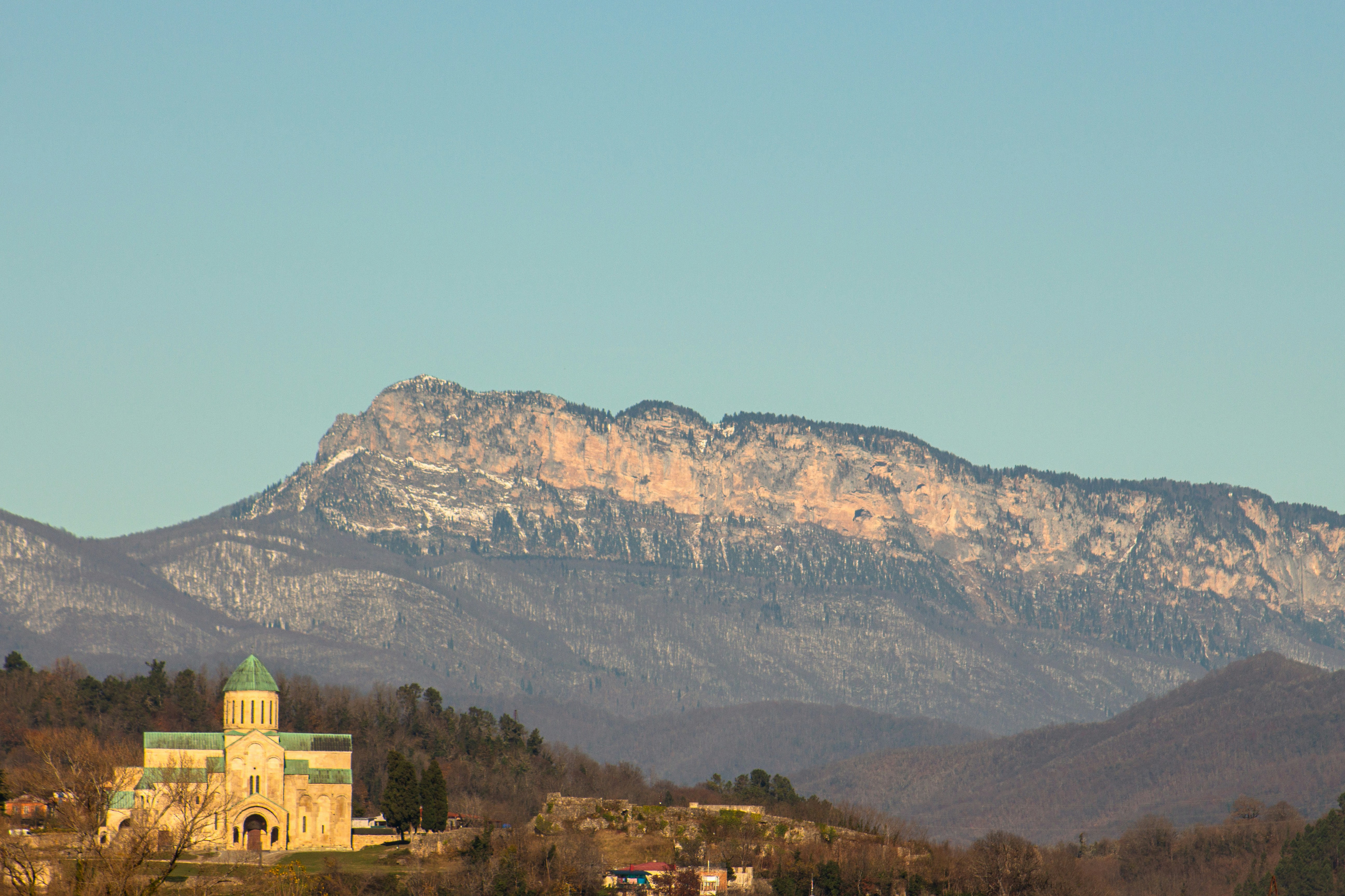 Monastery nestled below a majestic mountain range