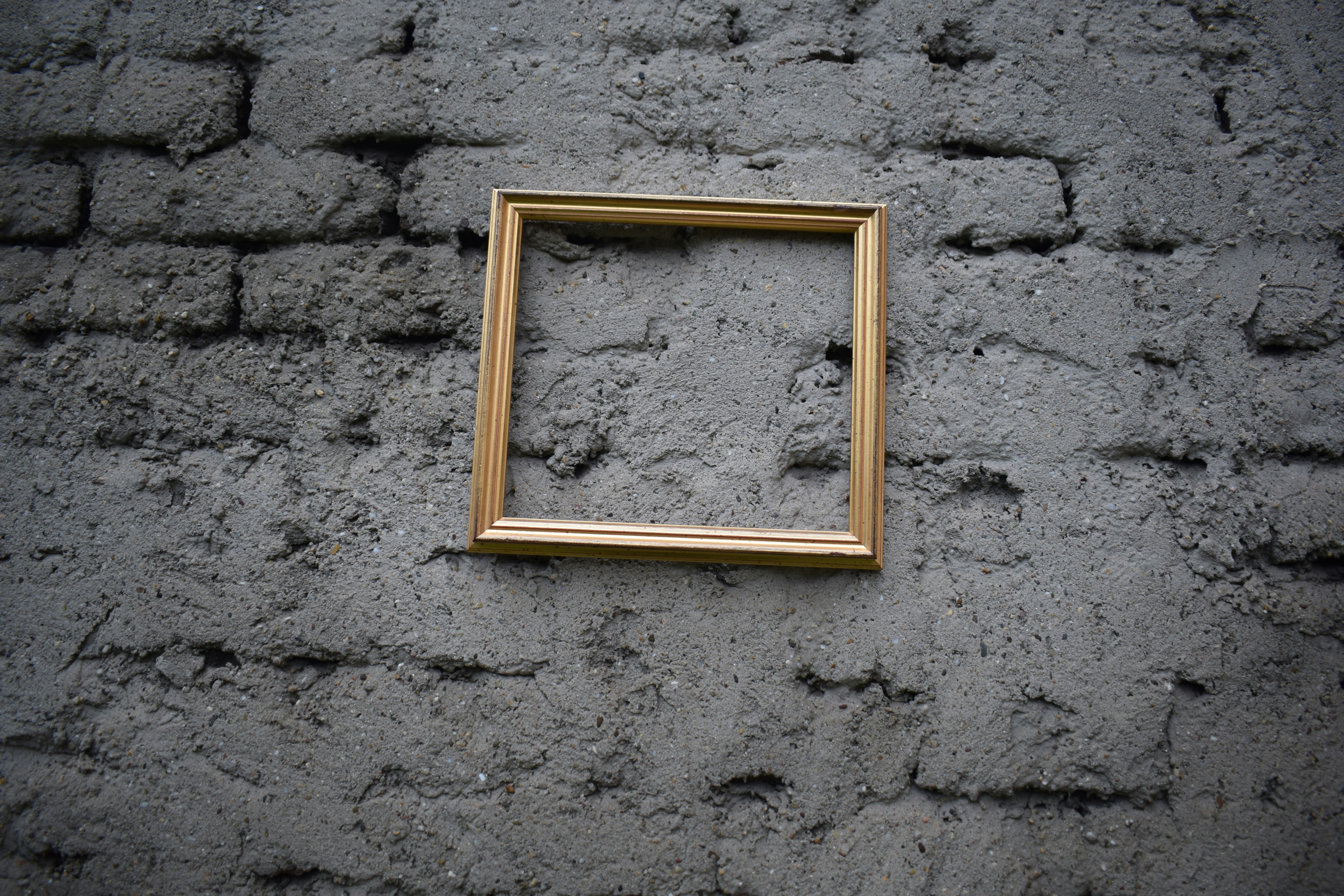 Leerer Holzrahmen an einer strukturierten Backsteinwand