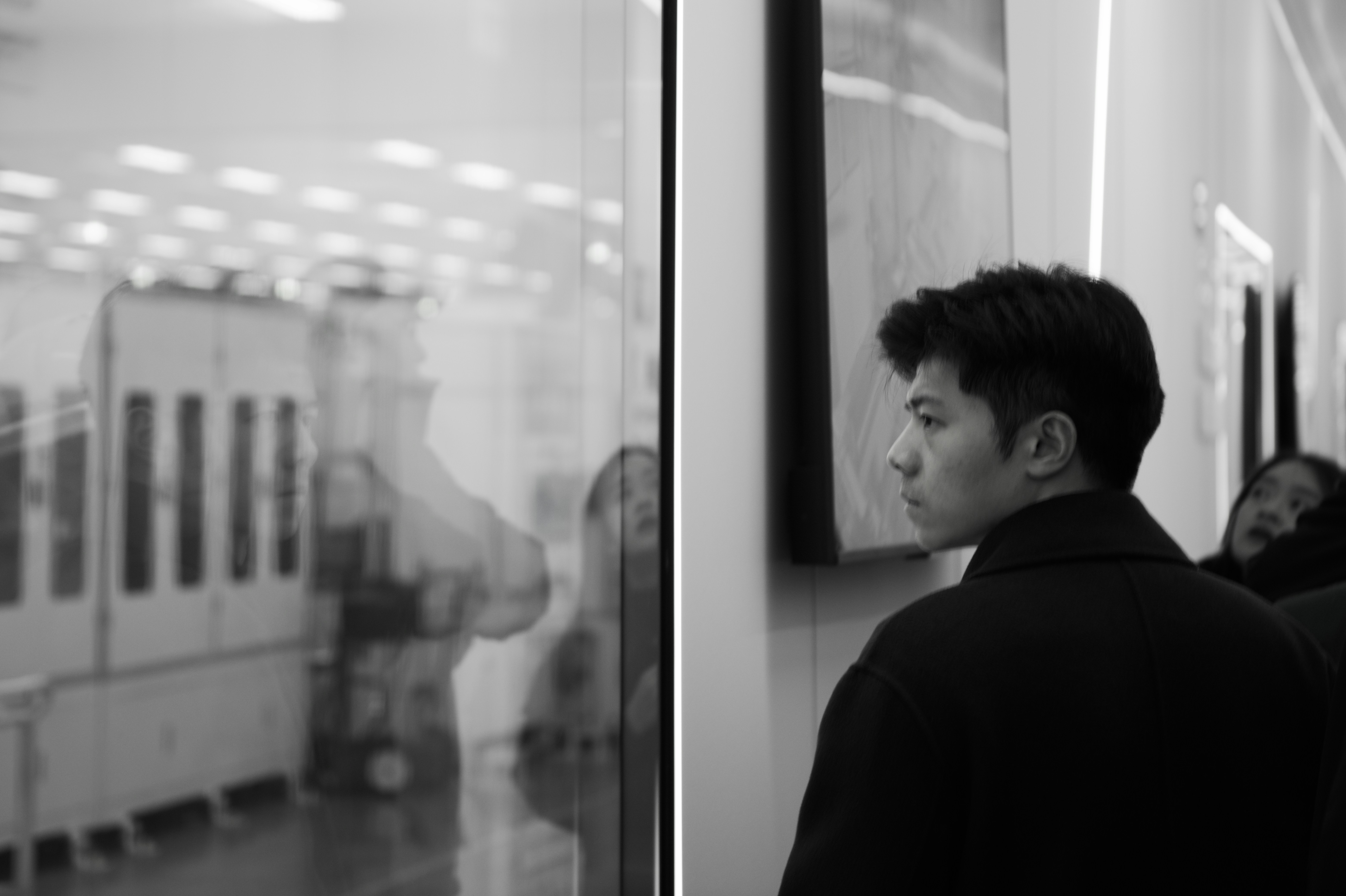 El hombre mira el reflejo en una pantalla de cristal.