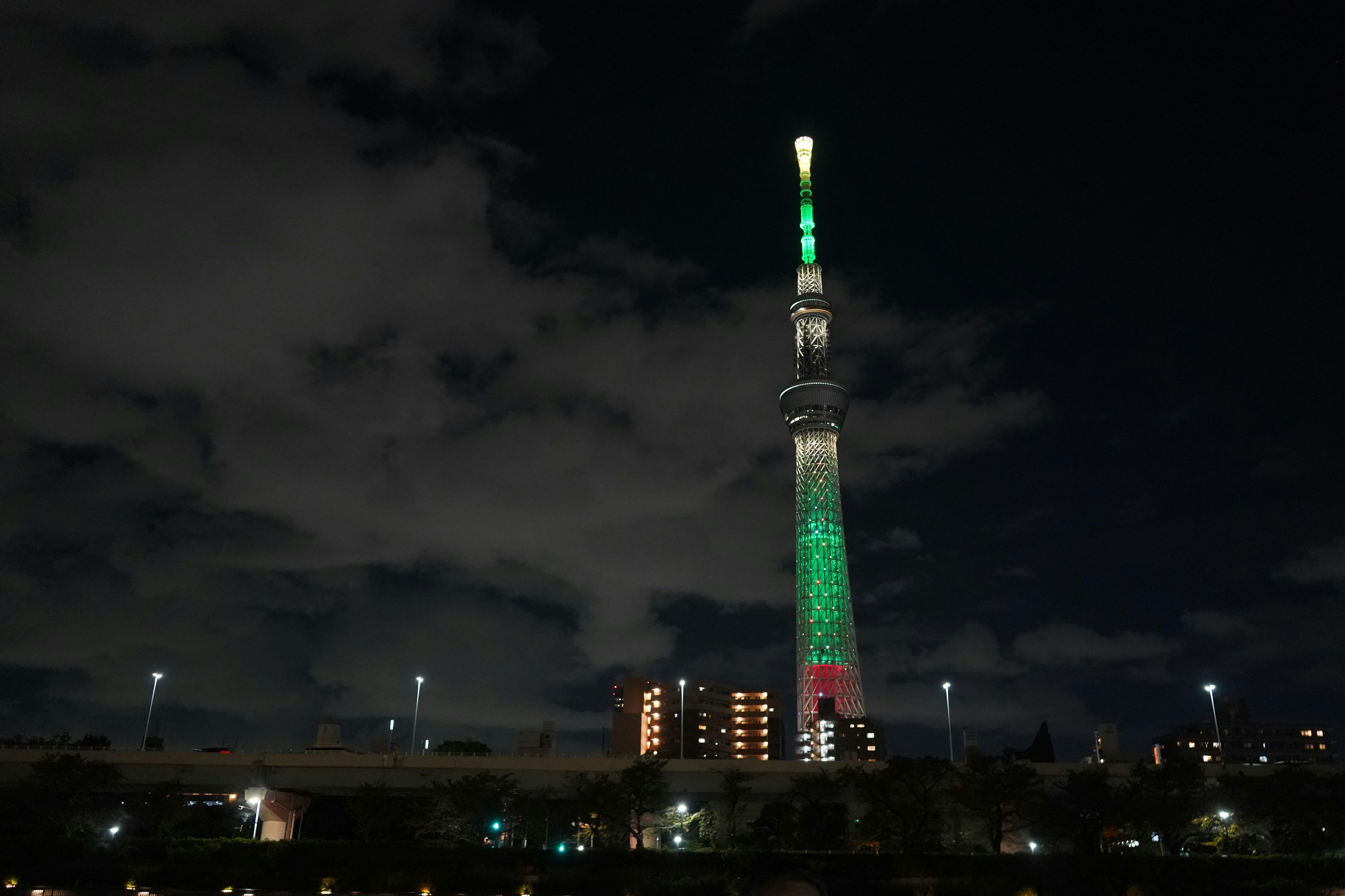 Tall illuminated tower at night with green lights