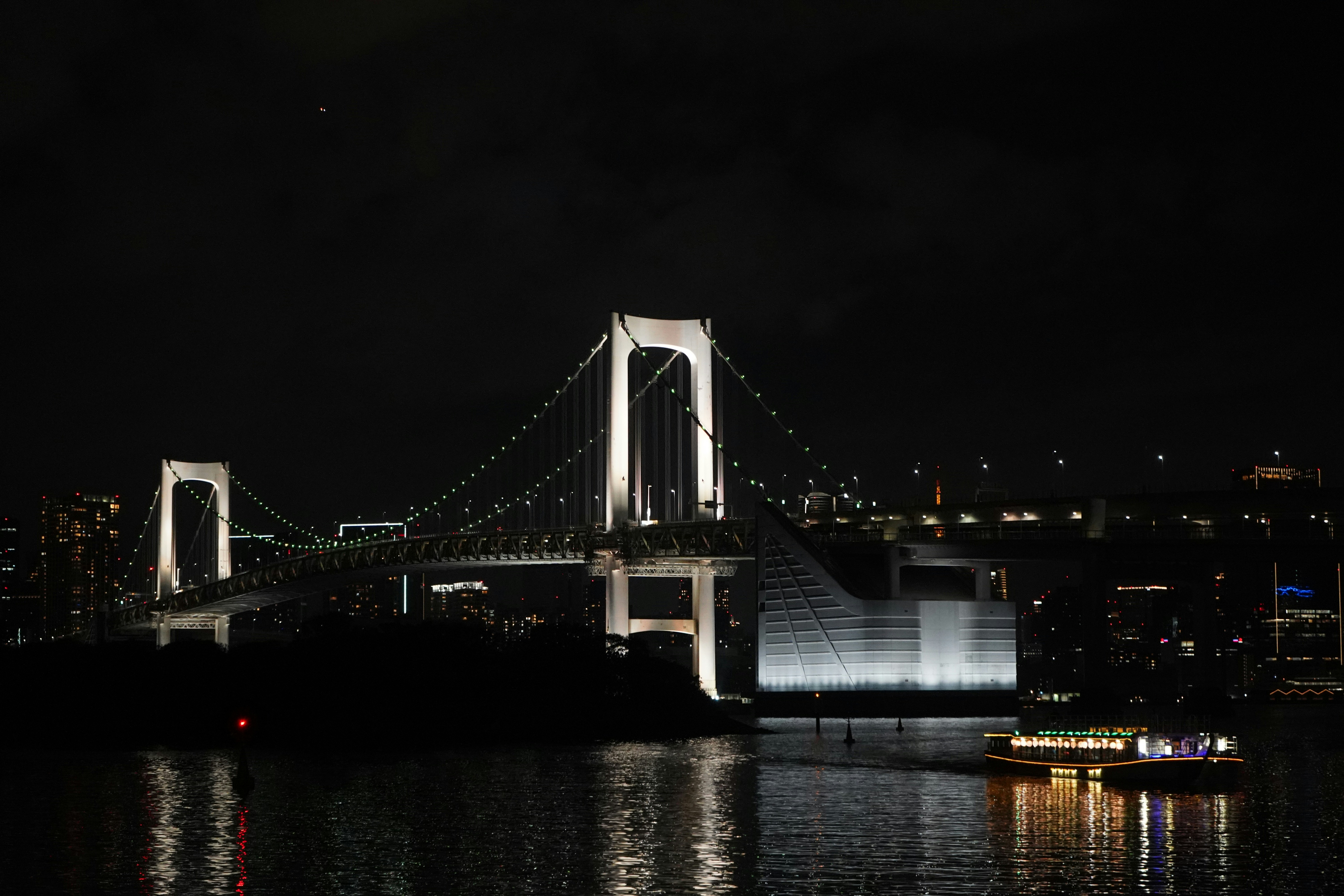 Illuminated bridge over water at night