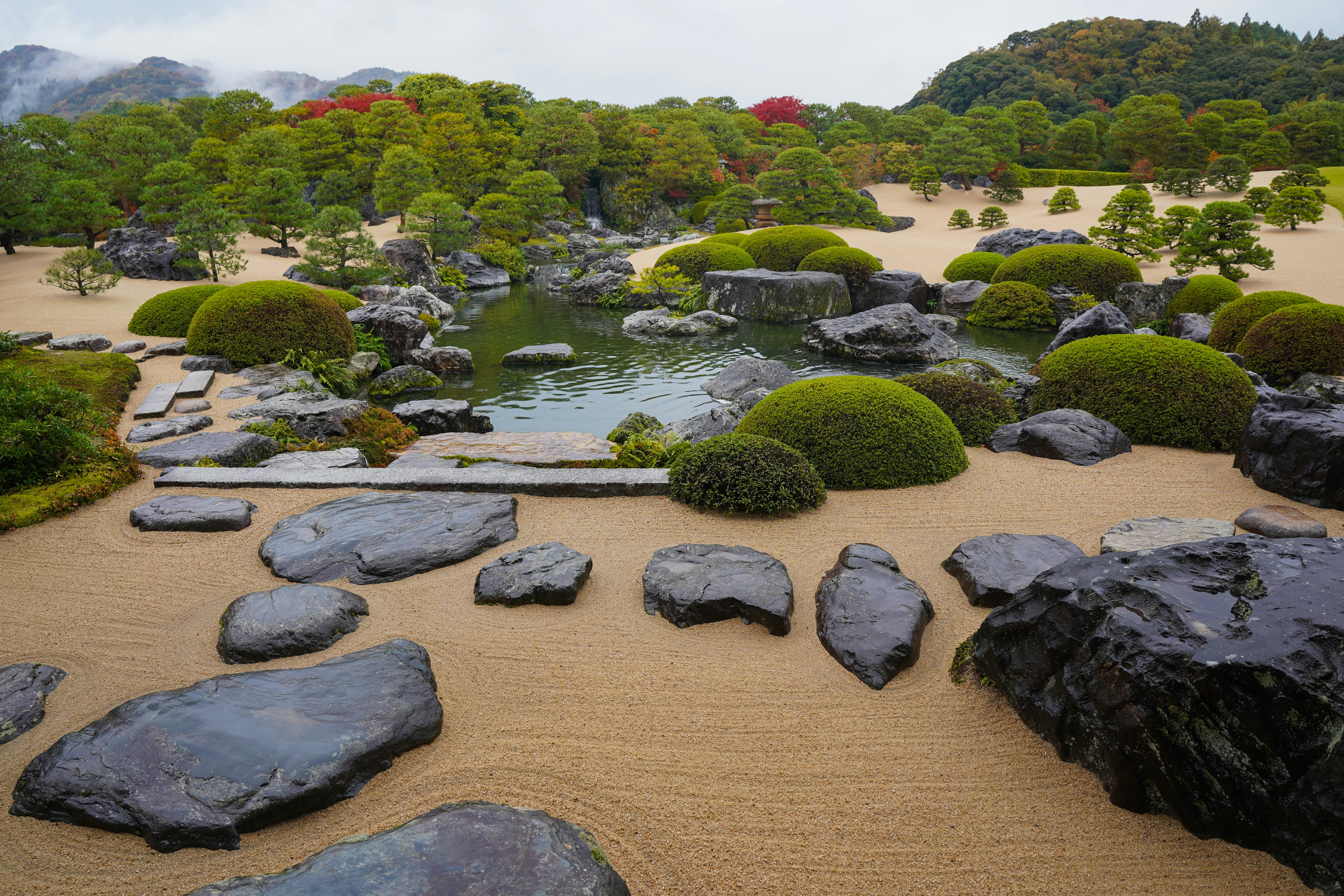 Japanese garden with raked sand and mossy rocks