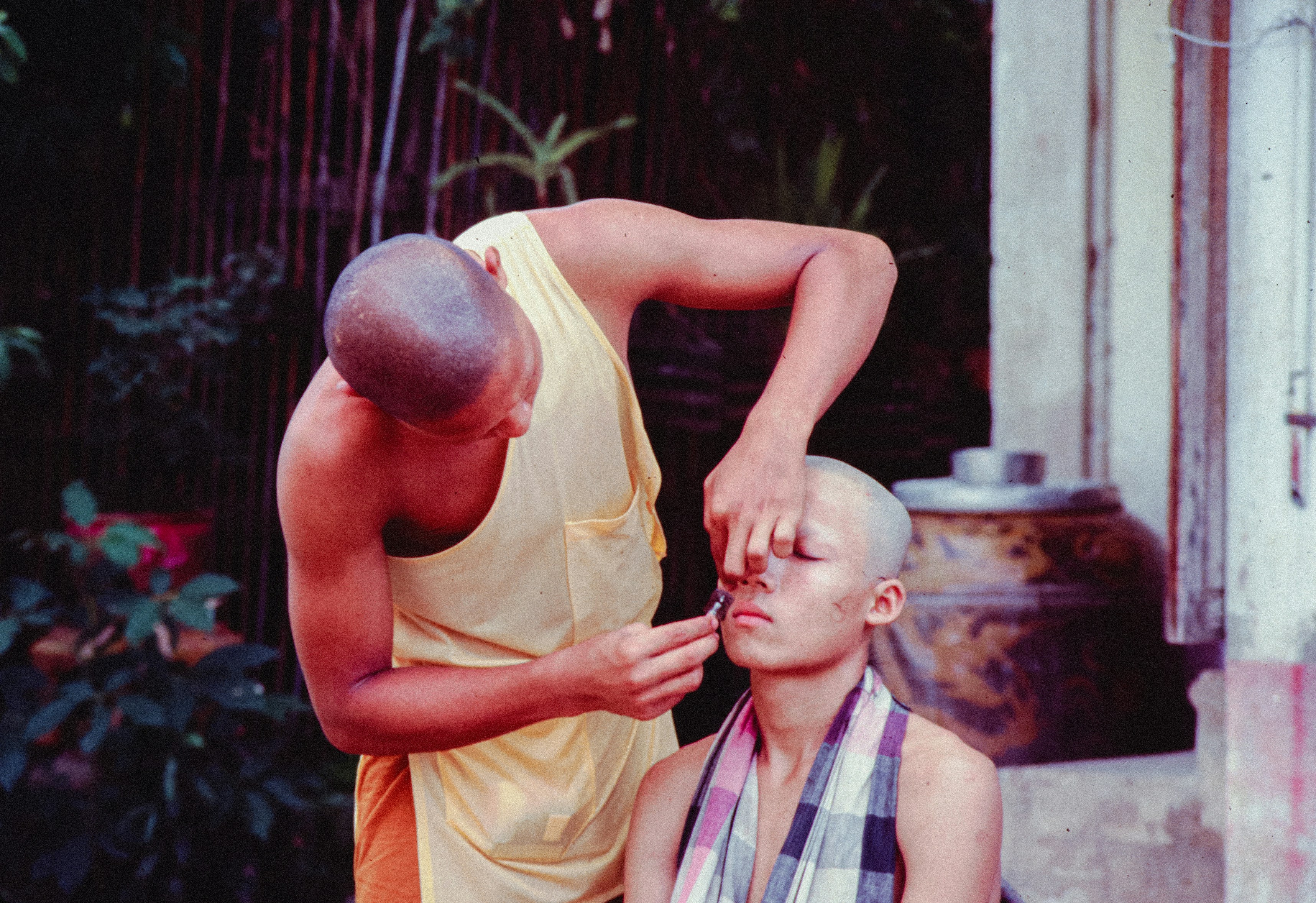 A close-up image showing a Balinese massage therapist performing a traditional massage technique on a client's back.
