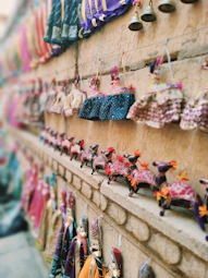Colorful traditional indian puppets displayed on a wall.