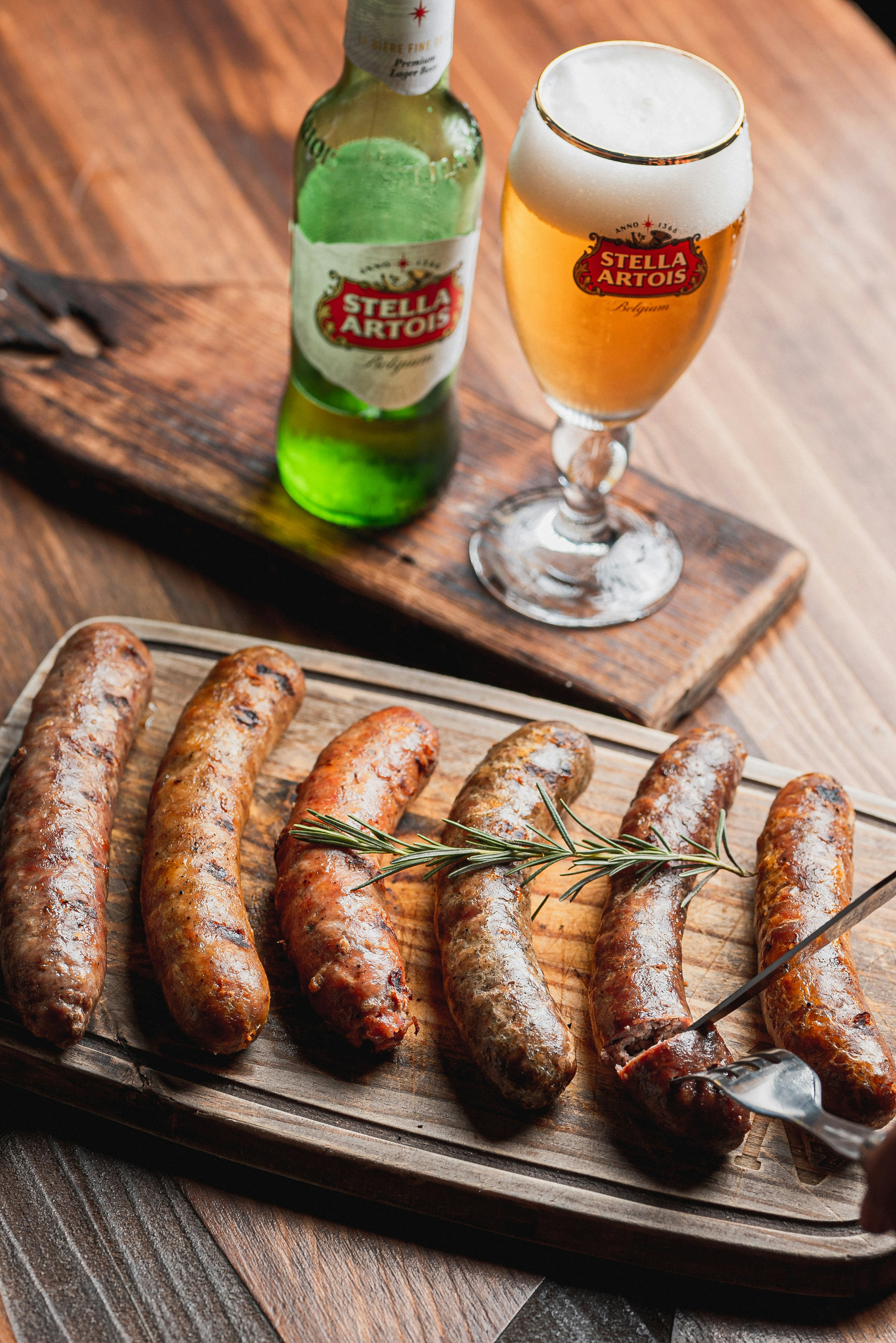 Grilled sausages with beer on wooden board