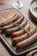 Several grilled sausages arranged on a wooden board