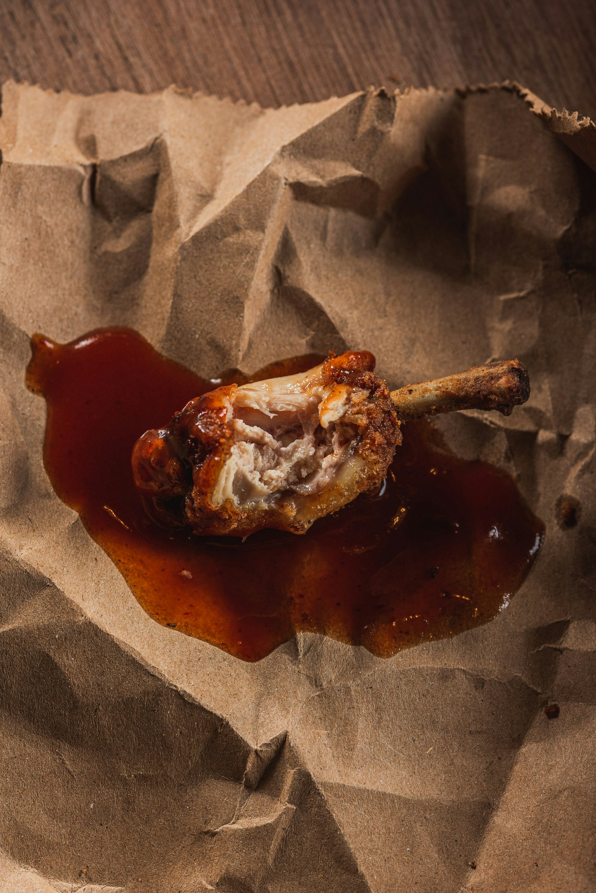 Fried chicken wing with barbecue sauce on brown paper