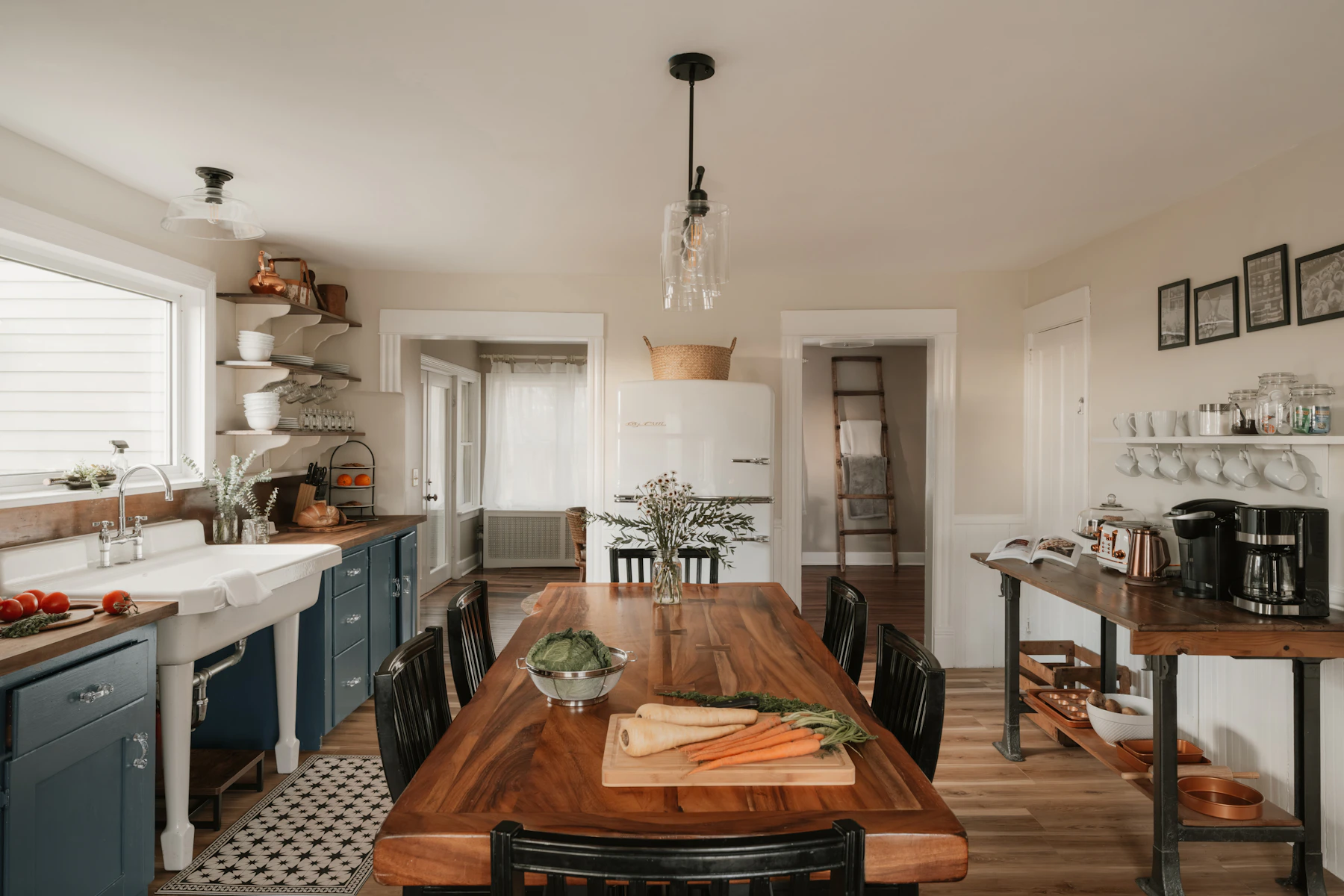 Warm farmhouse kitchen with dining table, island, natural light and visible food preparation
