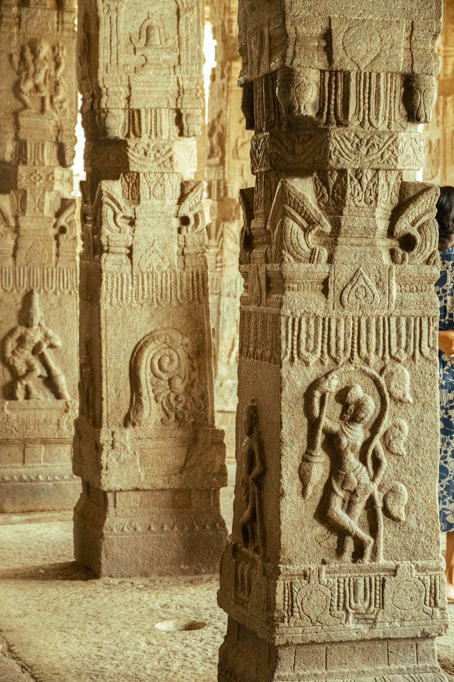 Ornate carved granite pillars inside a South Indian temple corridor, in the style of the Ramanathaswamy Temple