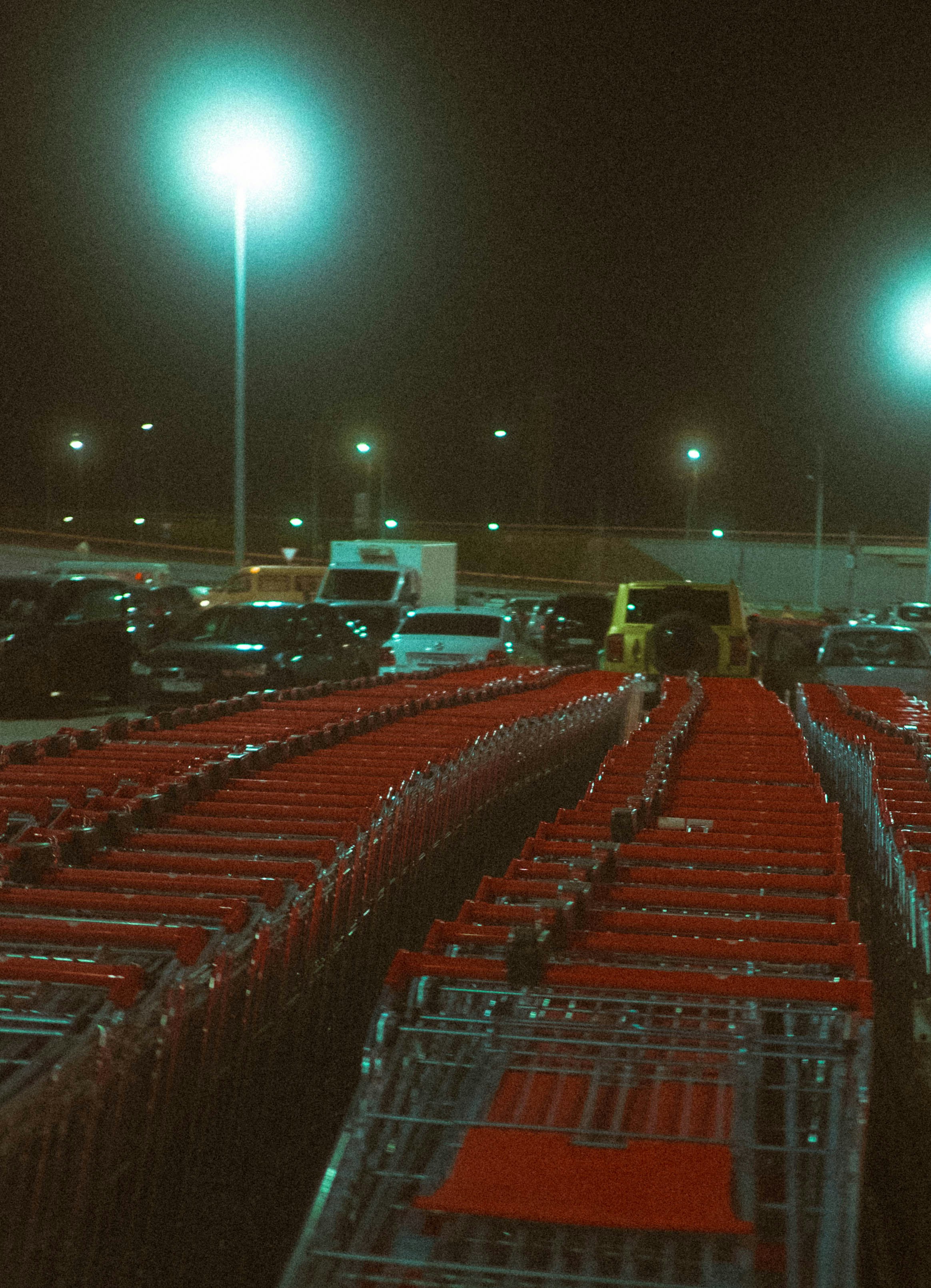 Rows of red shopping carts at night