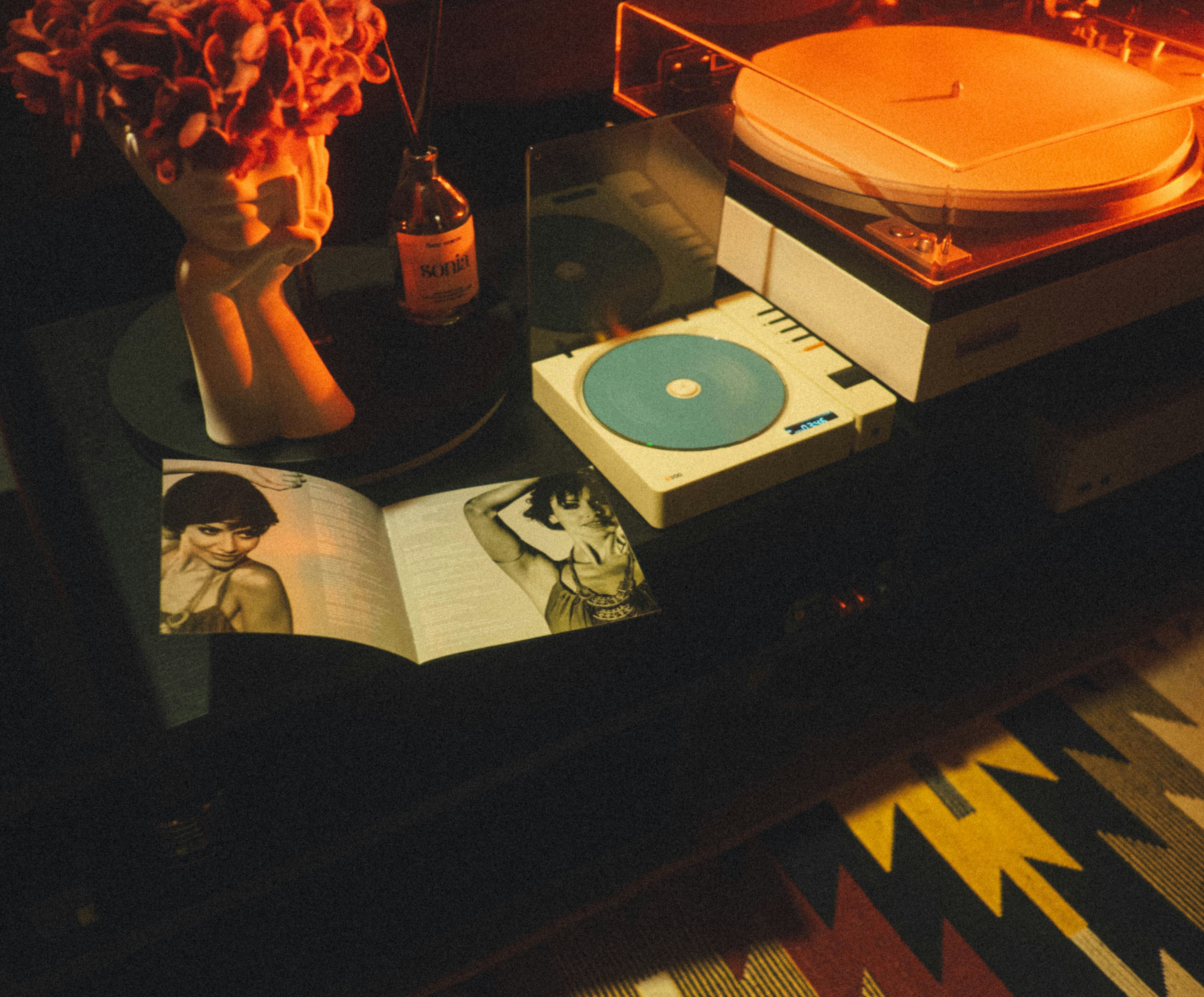 Vintage record player with open magazine on table.