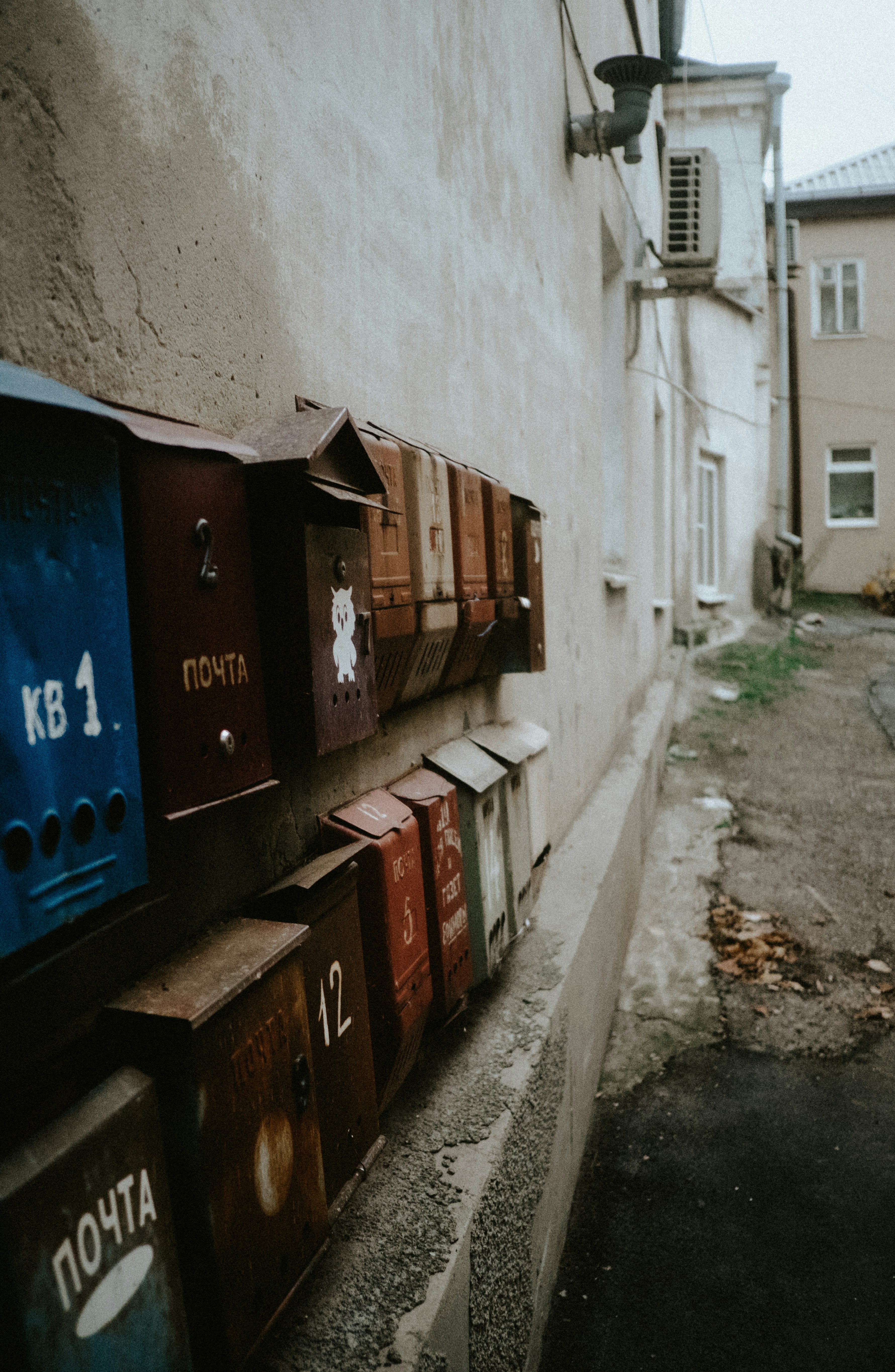 Row of old mailboxes on a weathered wall