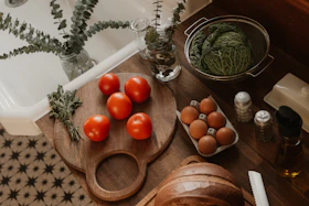 Tomatoes, eggs, and cabbage on a kitchen counter.