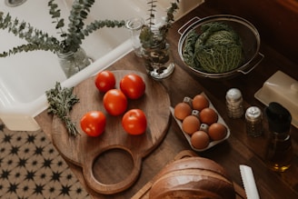 Tomatoes, eggs, and cabbage on a kitchen counter.