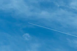 Airplane contrail across a clear blue sky.