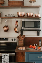 Kitchen counter with tomatoes, eggs, and utensils.
