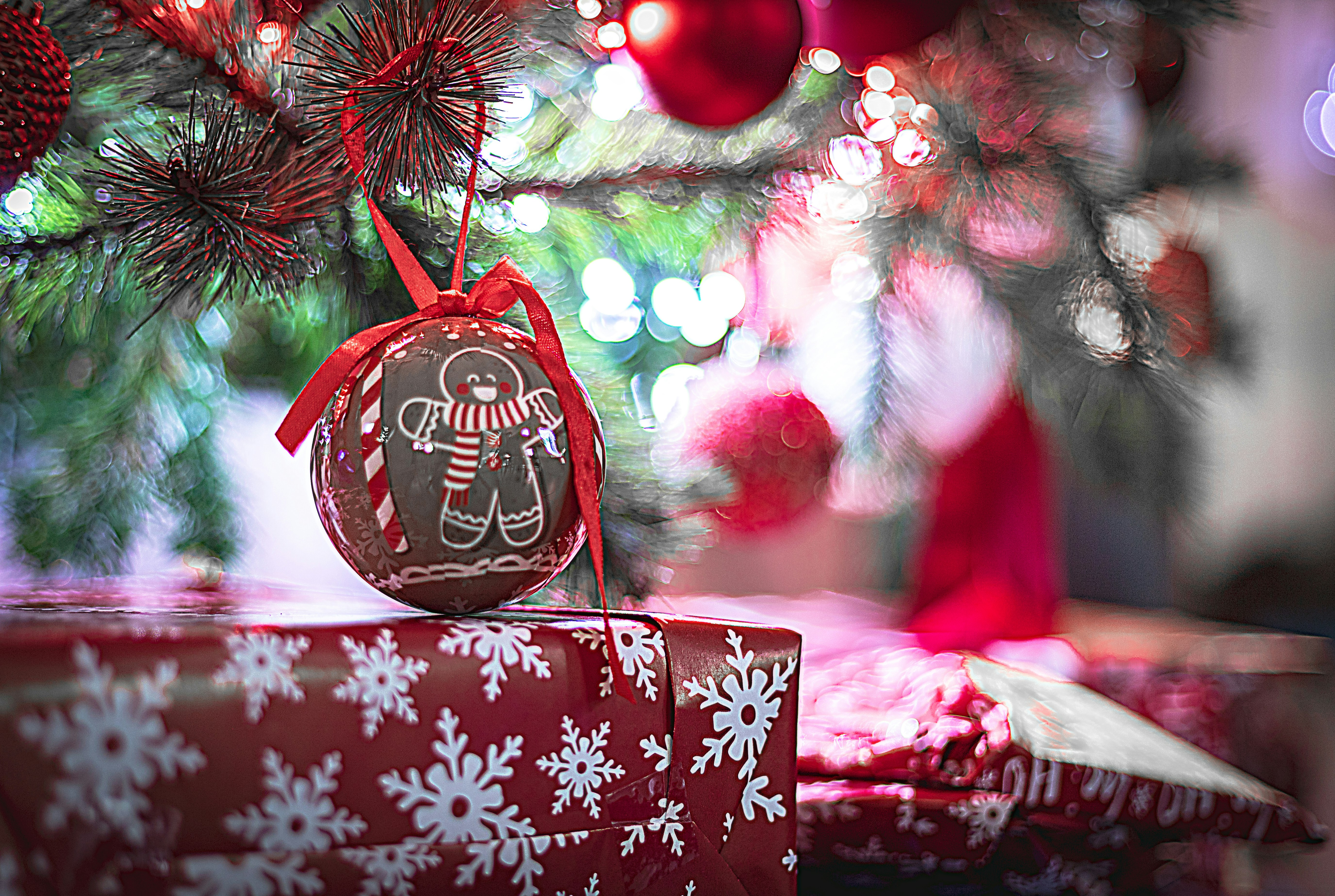 Gingerbread ornament hangs on a decorated christmas tree.