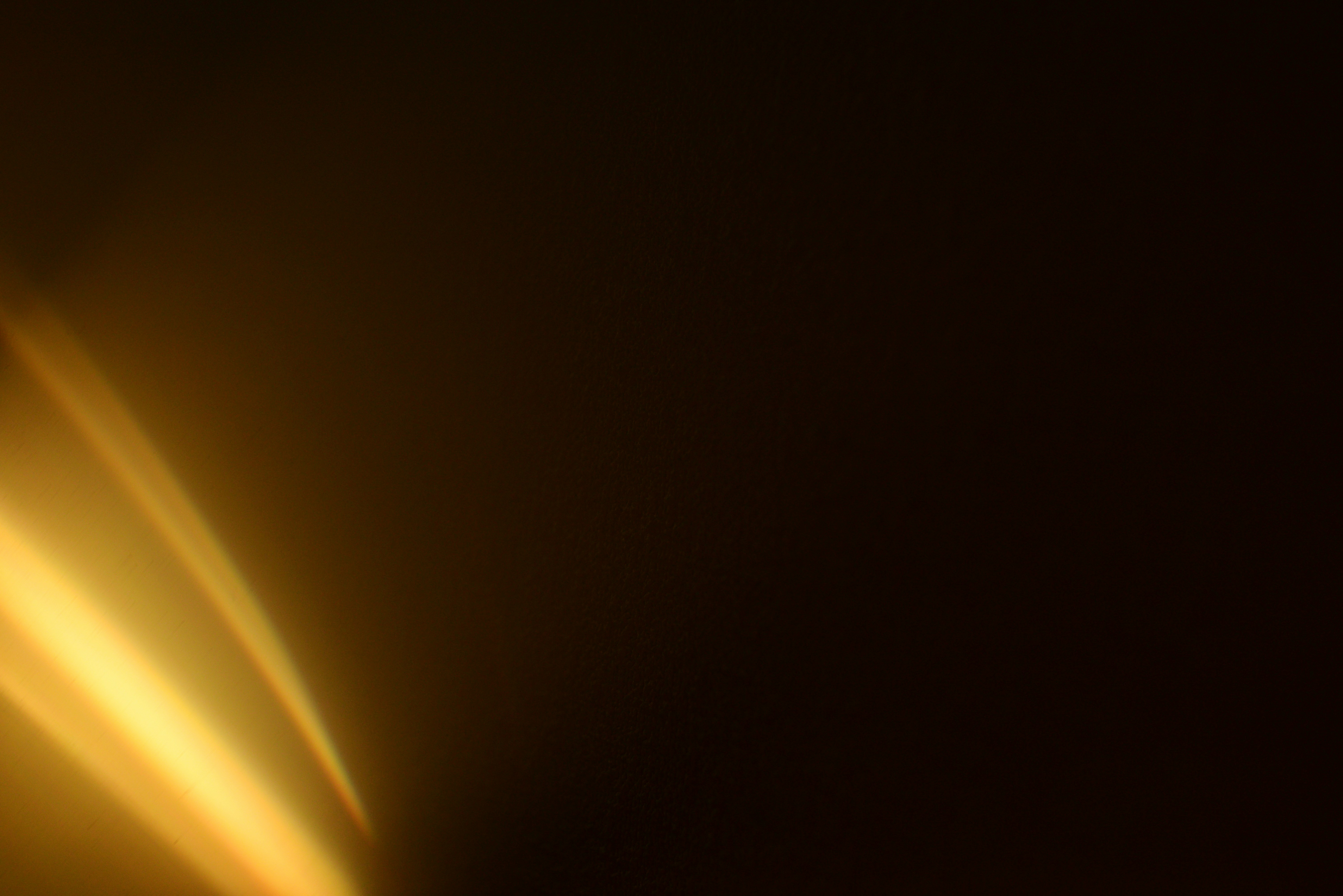 Golden light streaks across dark background