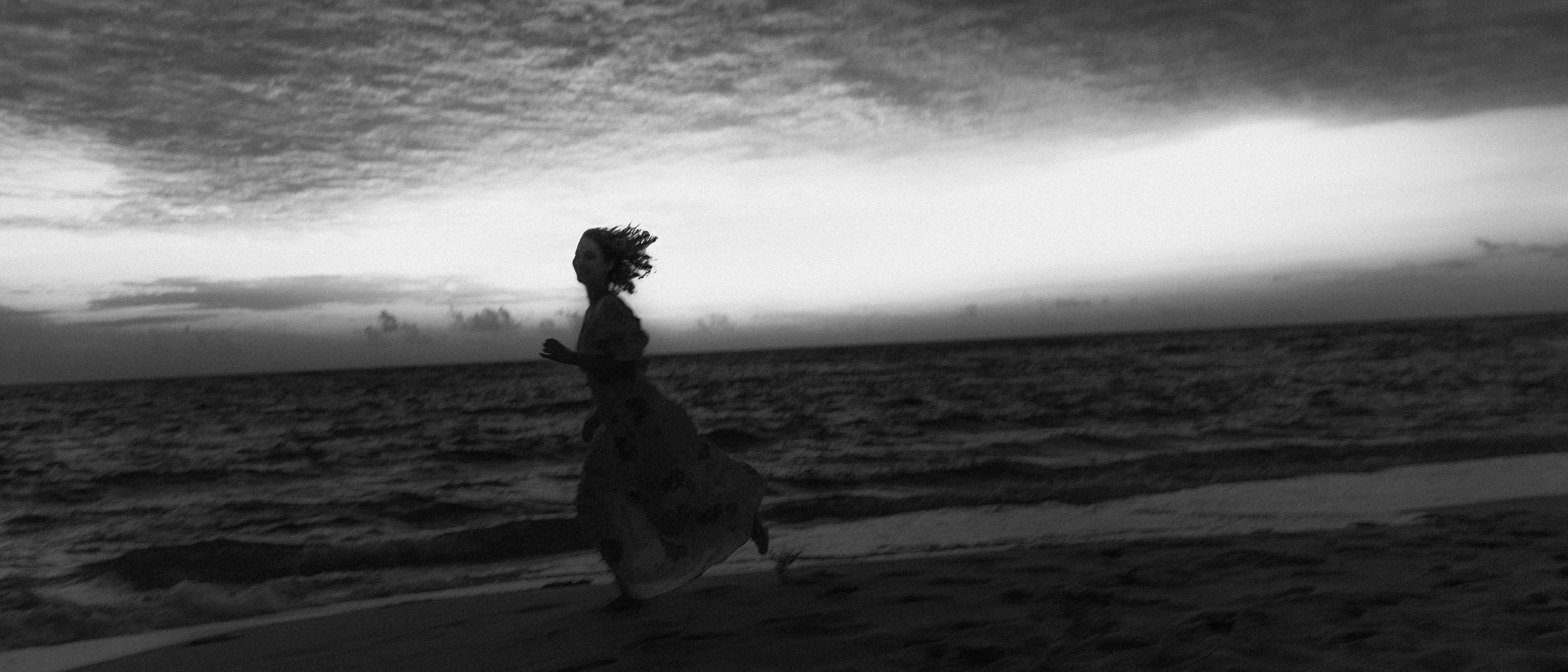 Silhouette of a woman running on a beach at sunset
