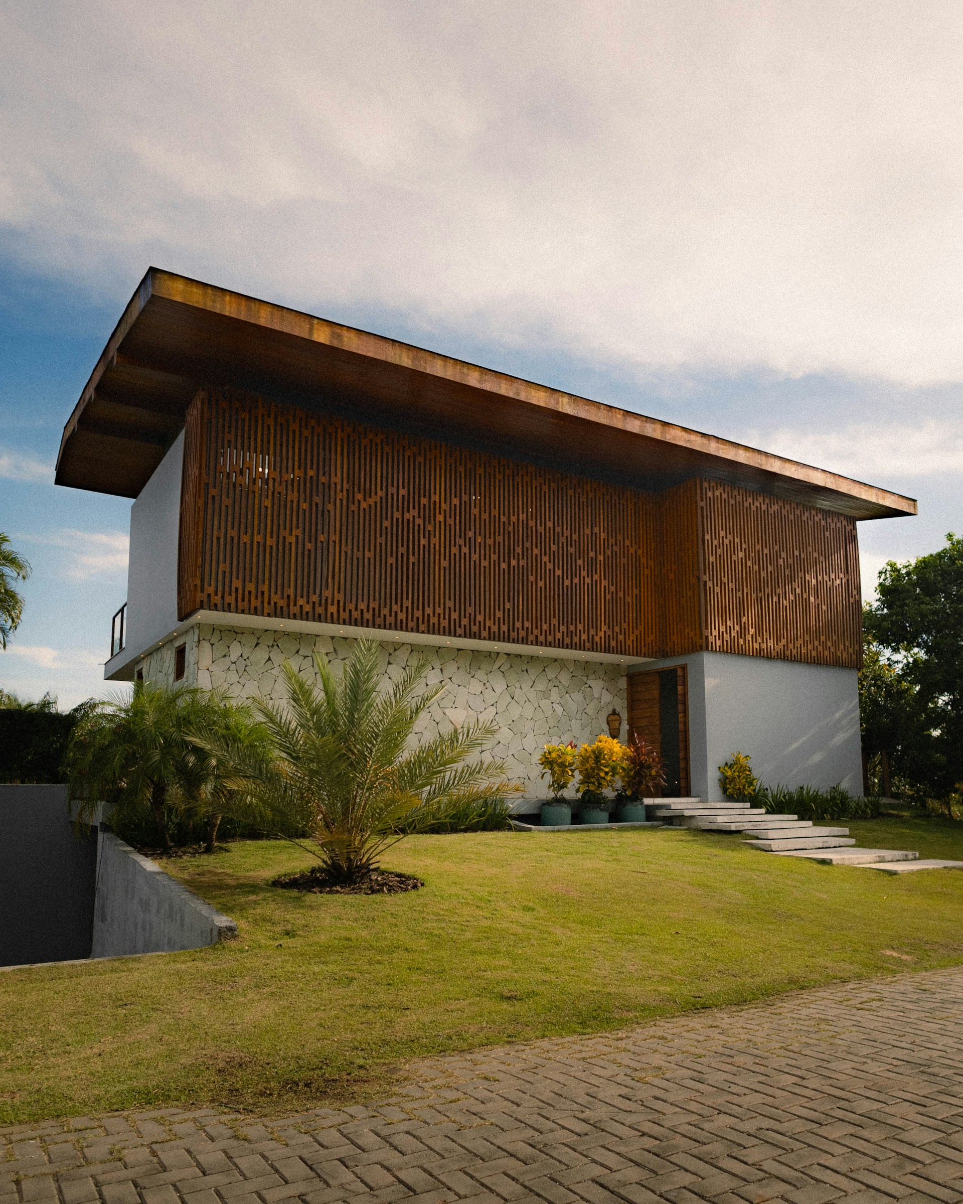 Modern house with wooden facade and green lawn.