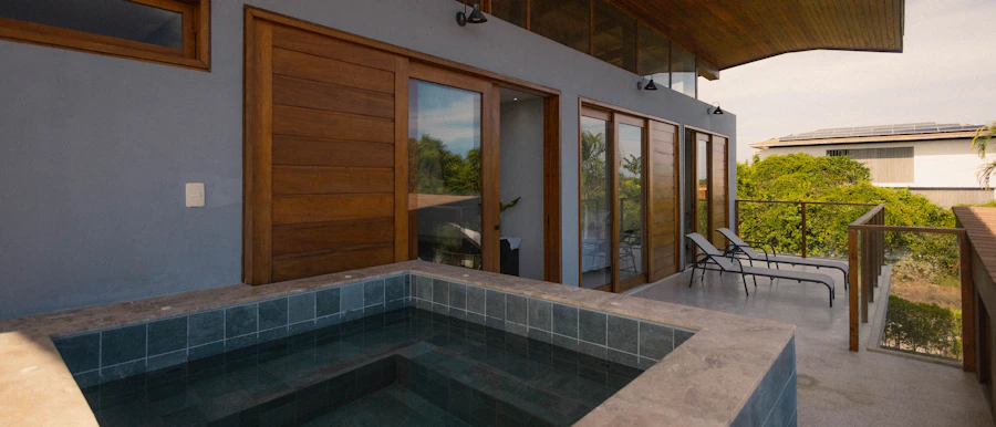 Jacuzzi extérieur en carrelage sur une terrasse avec transats