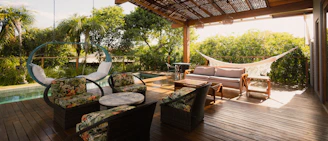 Covered patio with seating, hammock, and pool view.