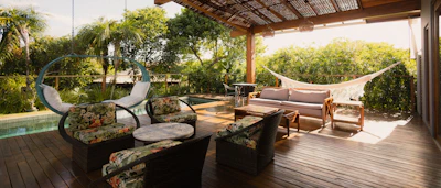 Covered patio with seating, hammock, and pool view.