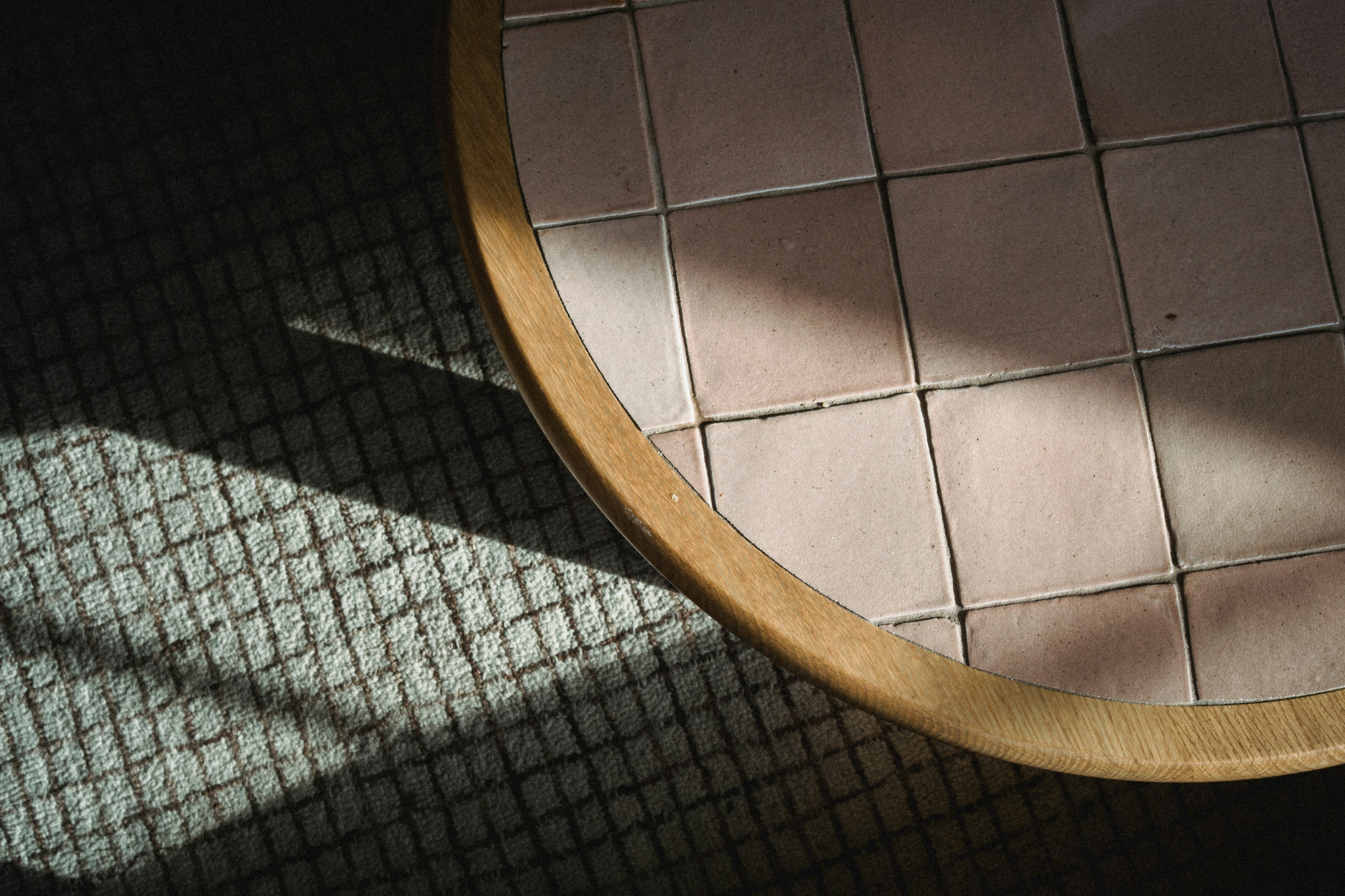 Close-up of a tiled surface with wooden trim