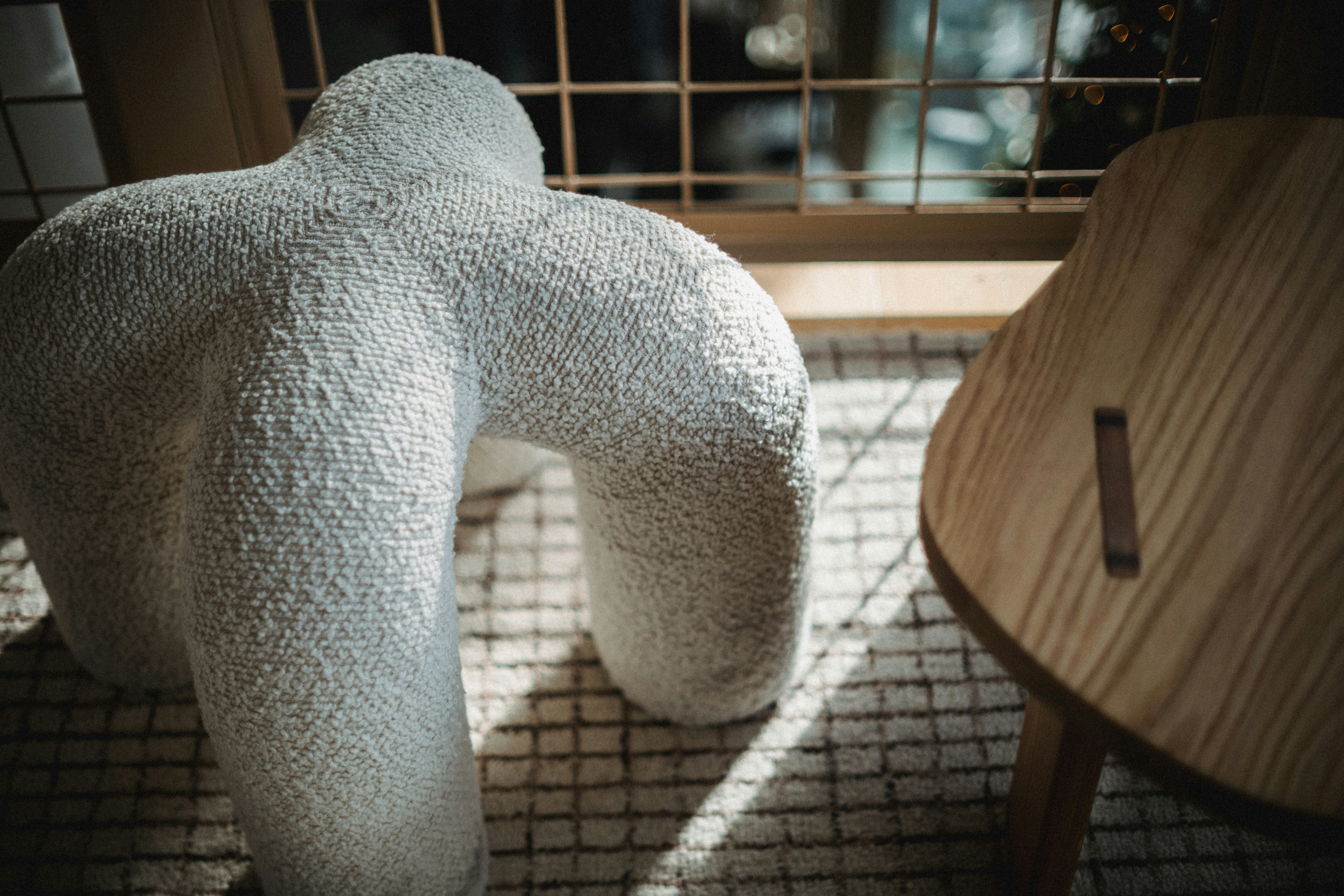 Textured abstract sculpture and wooden chair near window