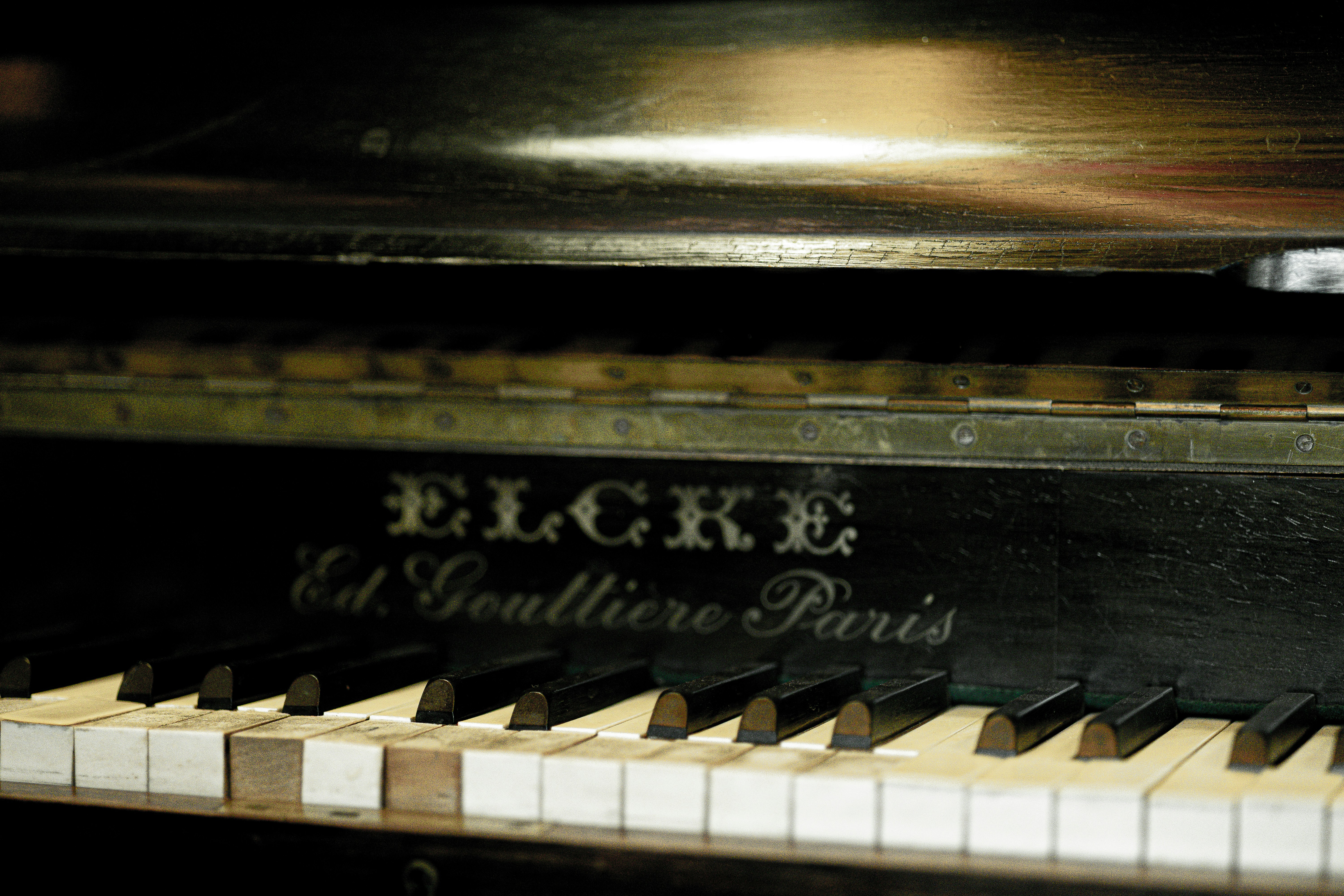 Close up of an old piano keyboard and nameplate.