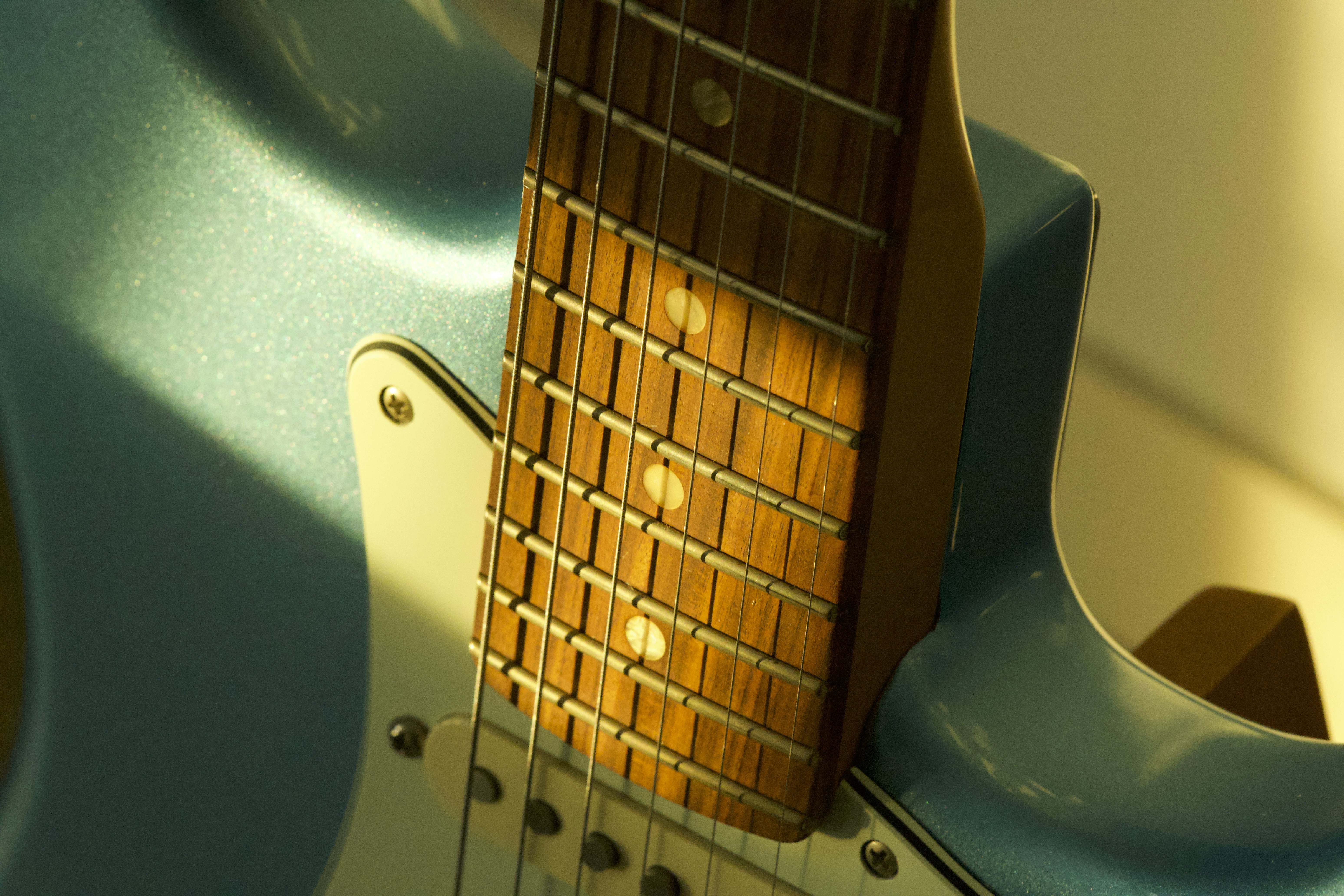 Close-up of a light blue electric guitar neck.