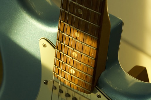 Close-up of a light blue electric guitar neck.