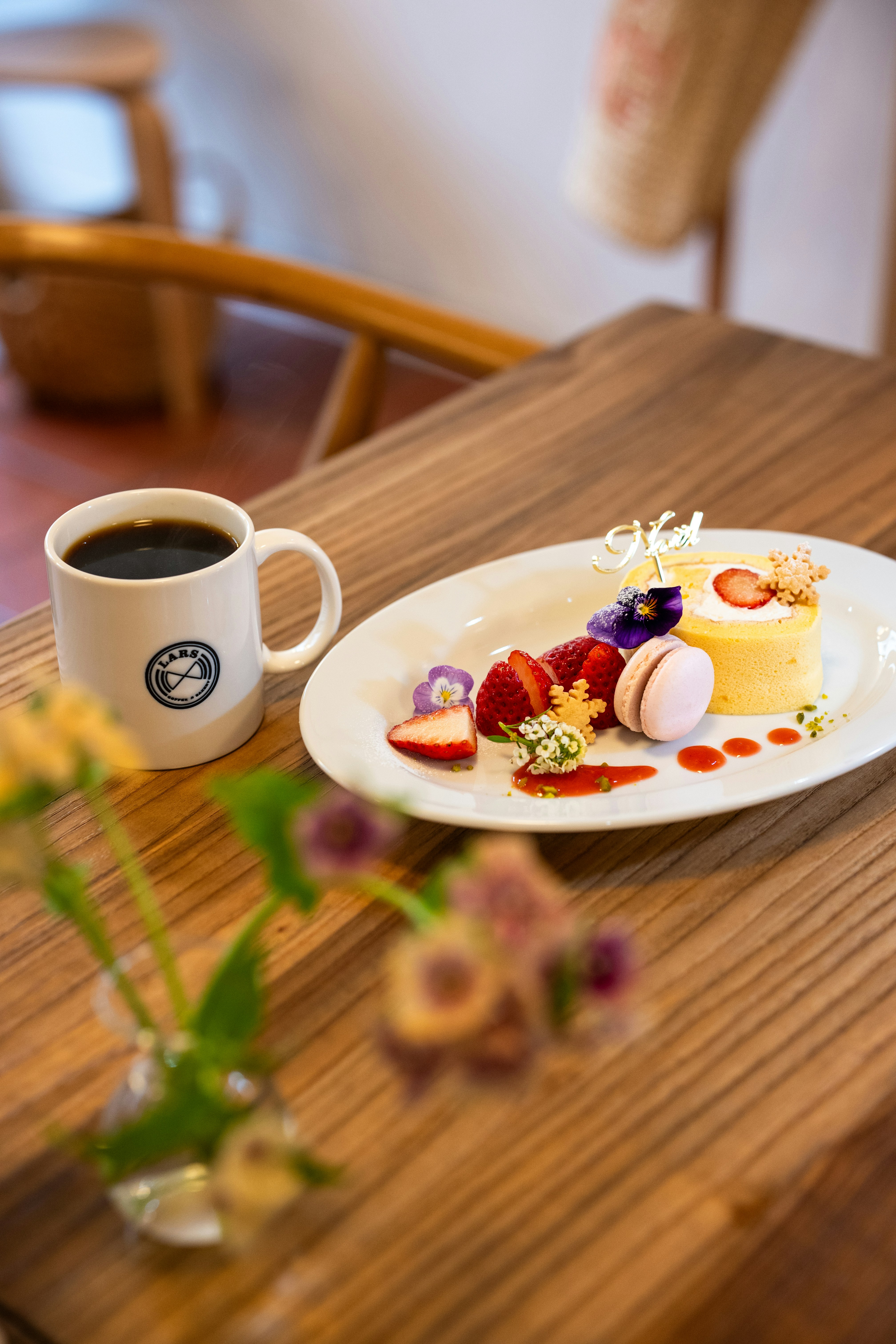 Dessert with strawberries and coffee on a wooden table.