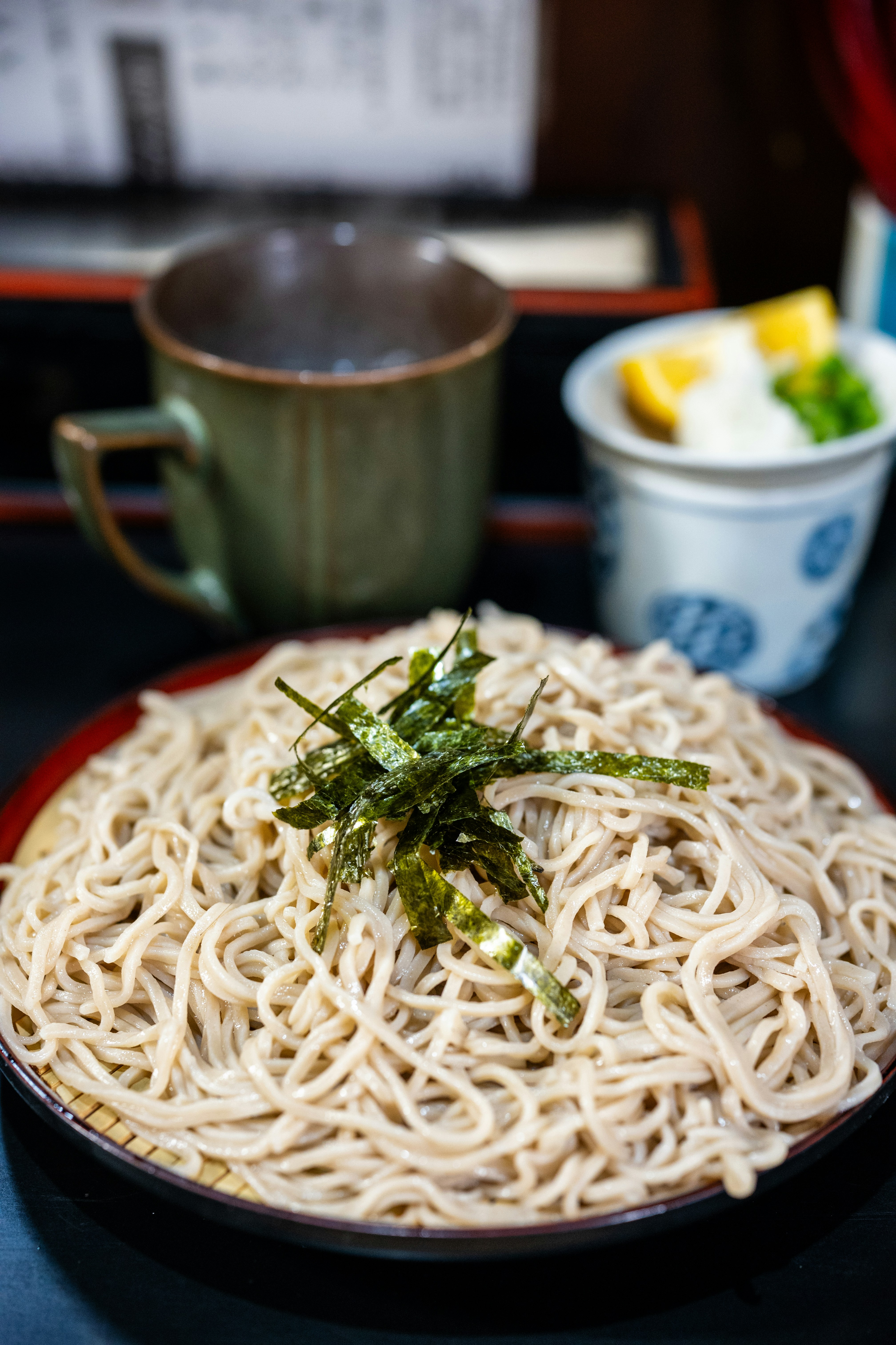 Soba noodles with seaweed and a side of dipping sauce.