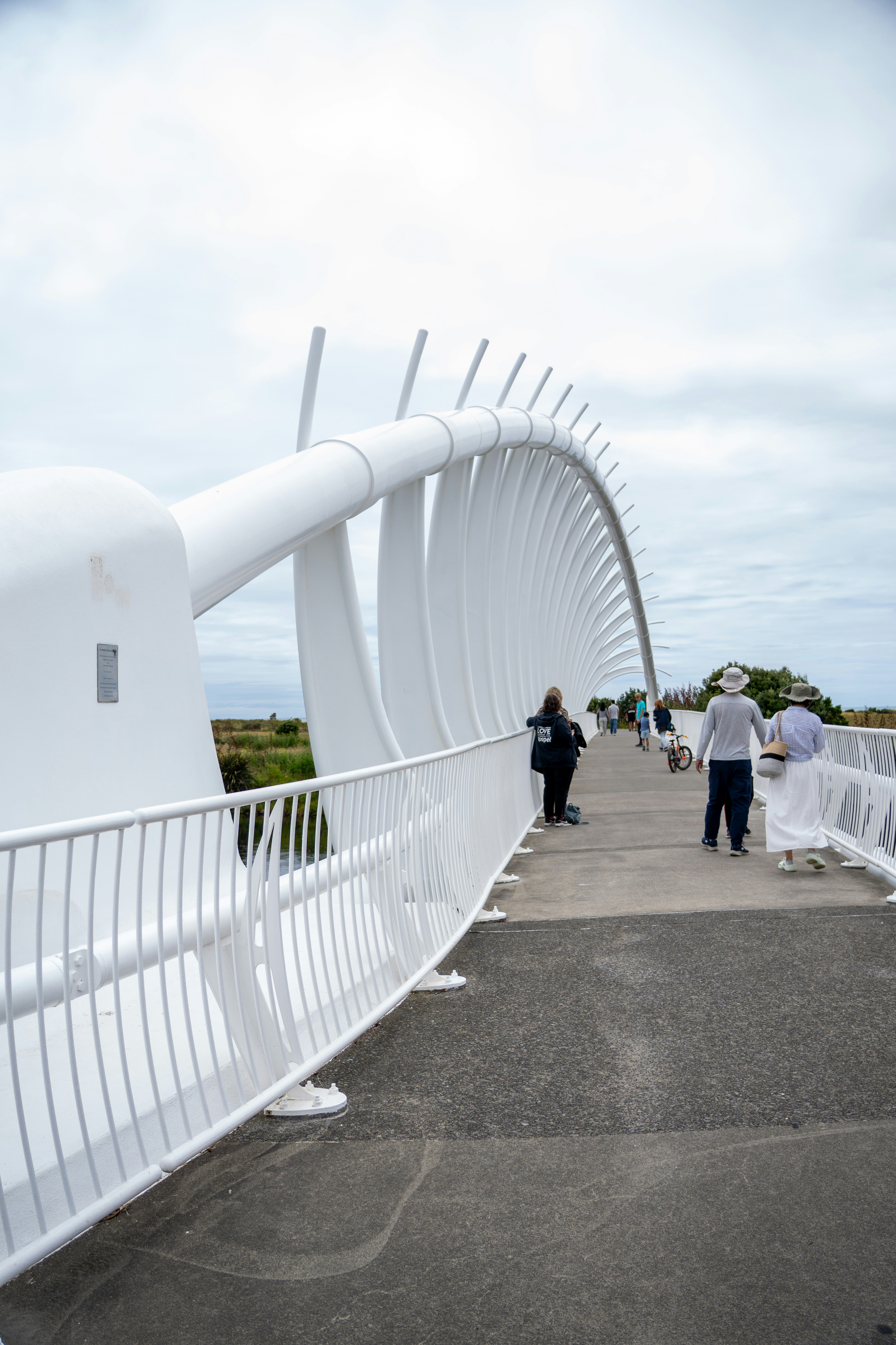 Menschen, die auf einer modernen weißen Fußgängerbrücke gehen