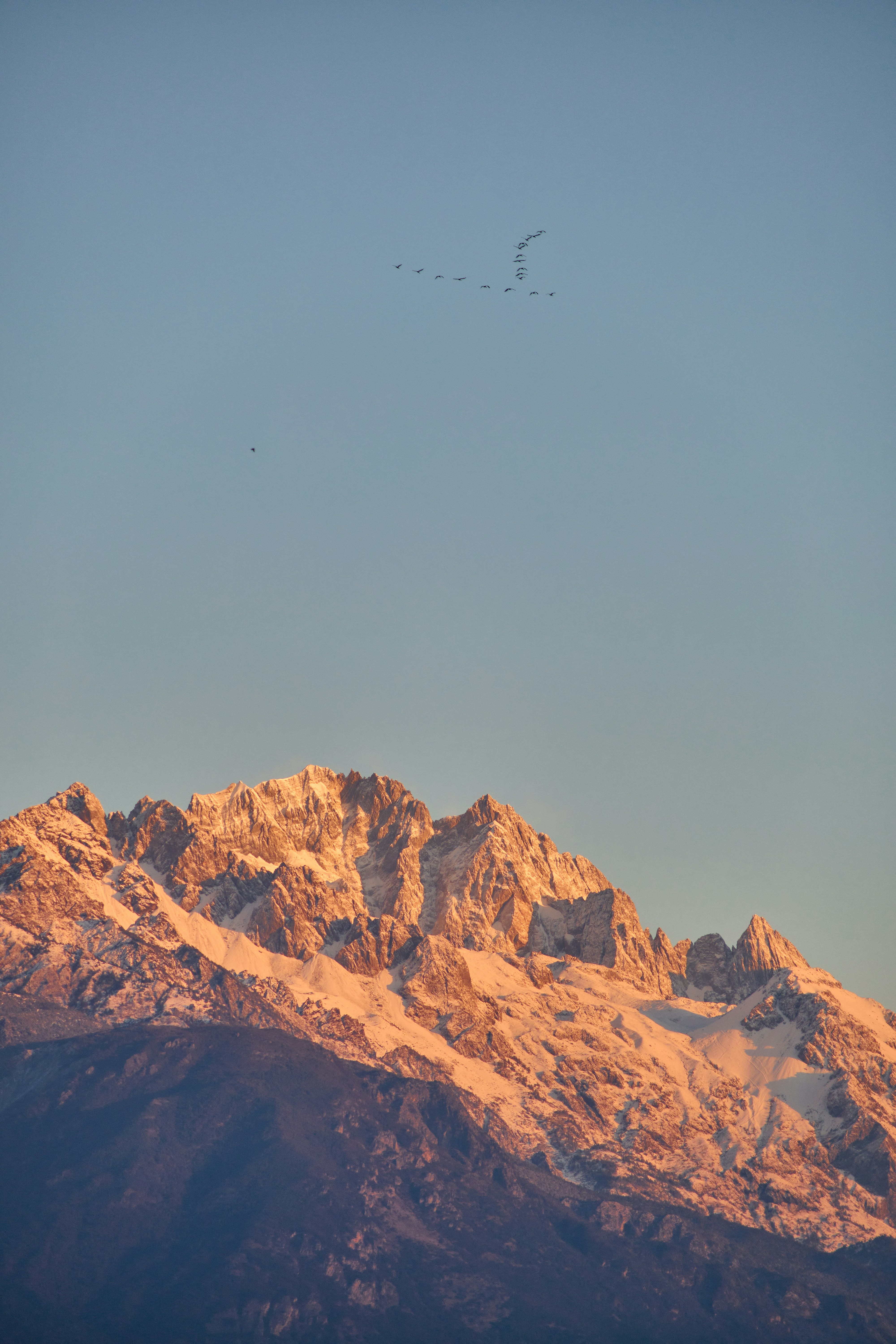 Montagne innevate illuminate dalla luce dorata del tramonto.
