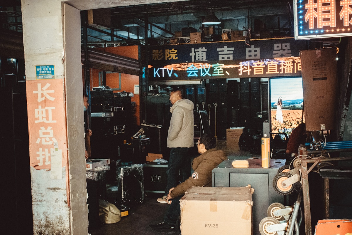 Two men in a dimly lit electronics store with equipment.