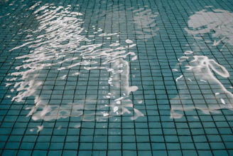 Rippling water surface over a tiled pool bottom.