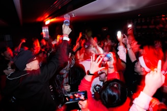 Crowd raising hands at a concert with red lights