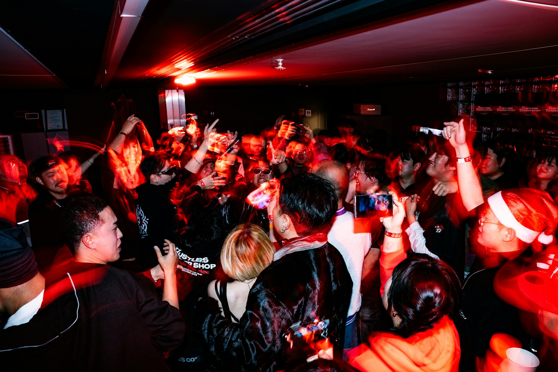 Crowd dancing at a red-lit concert orgy