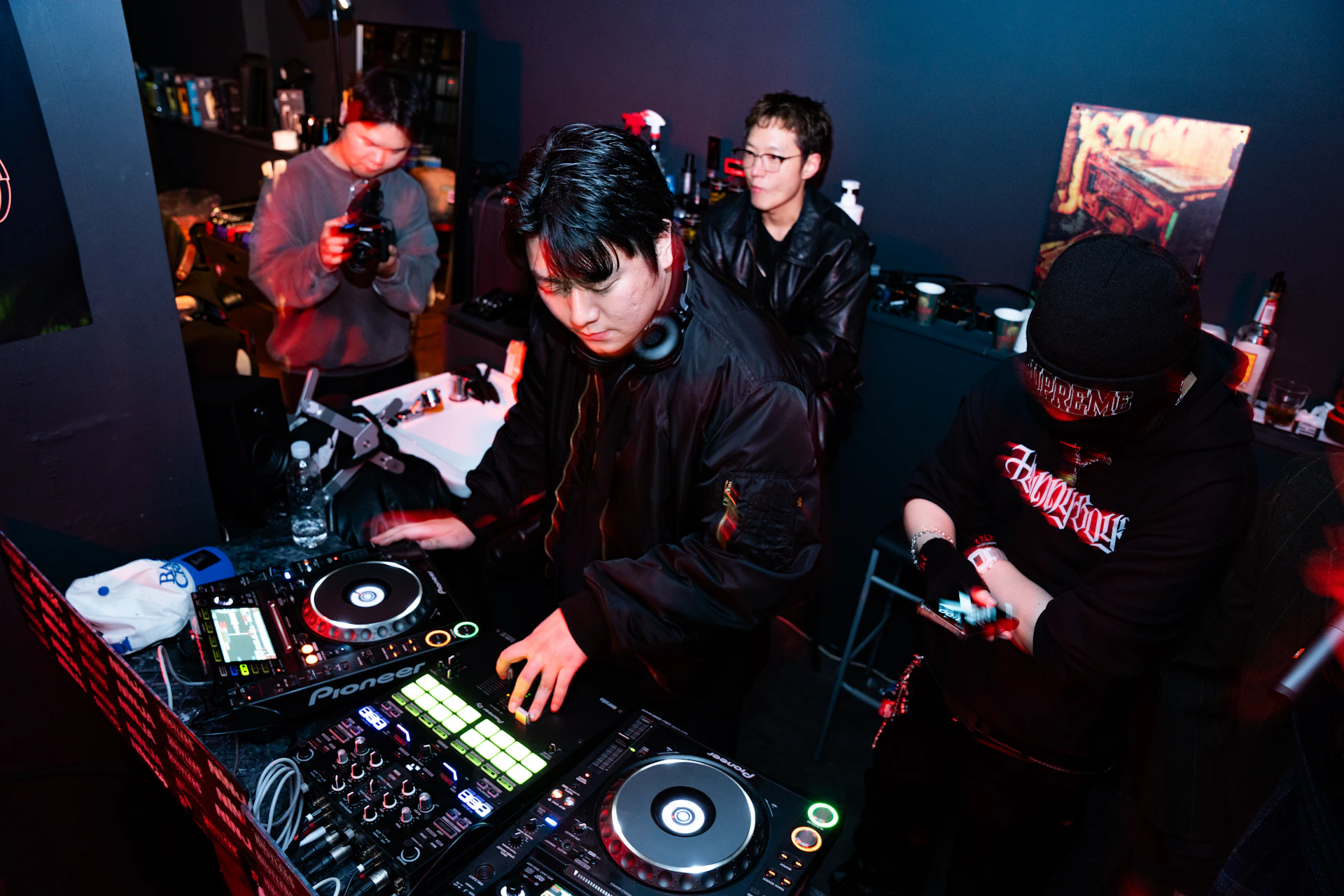 Dj performing at a turntable with crowd in background