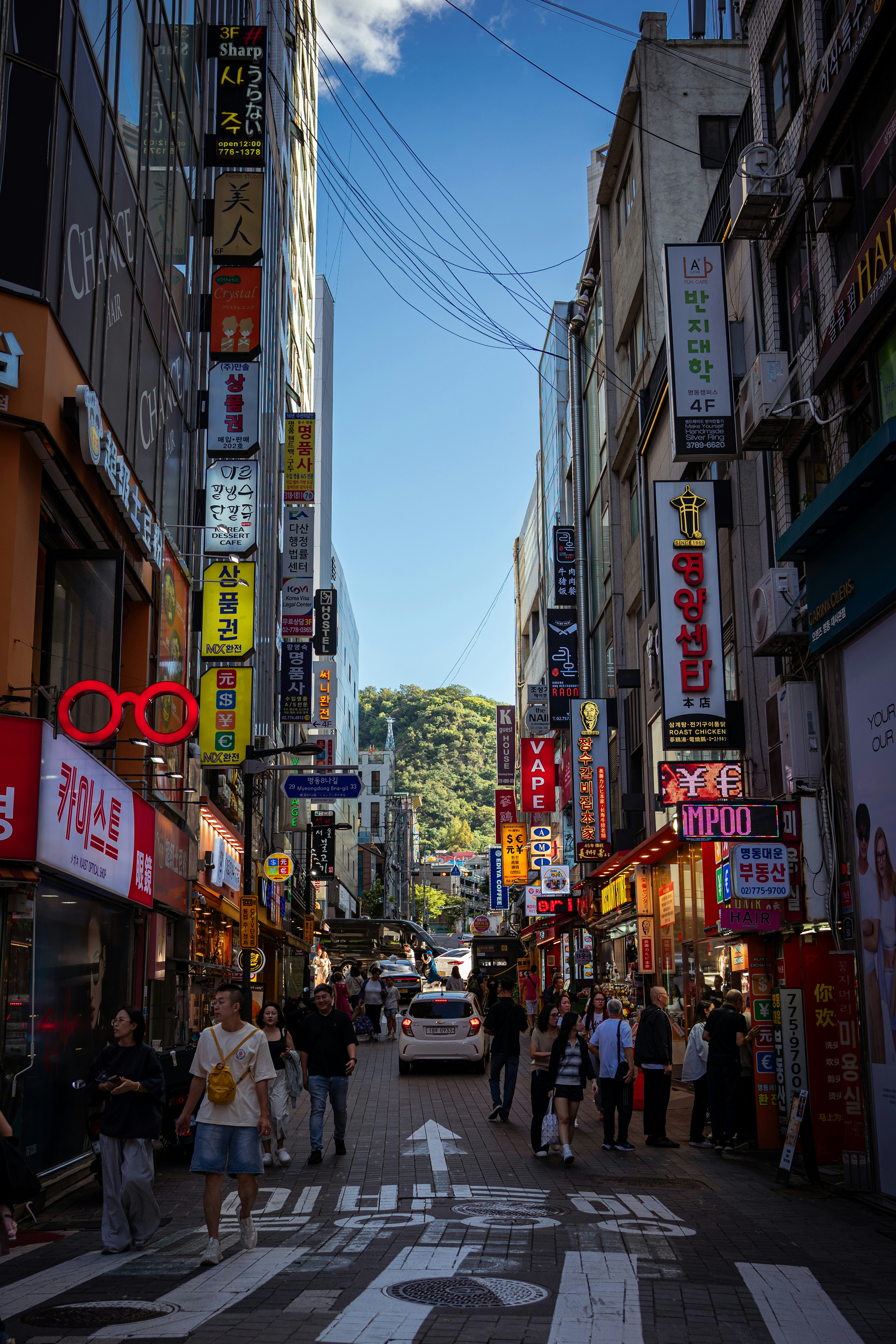 Busy city street with many signs and people.