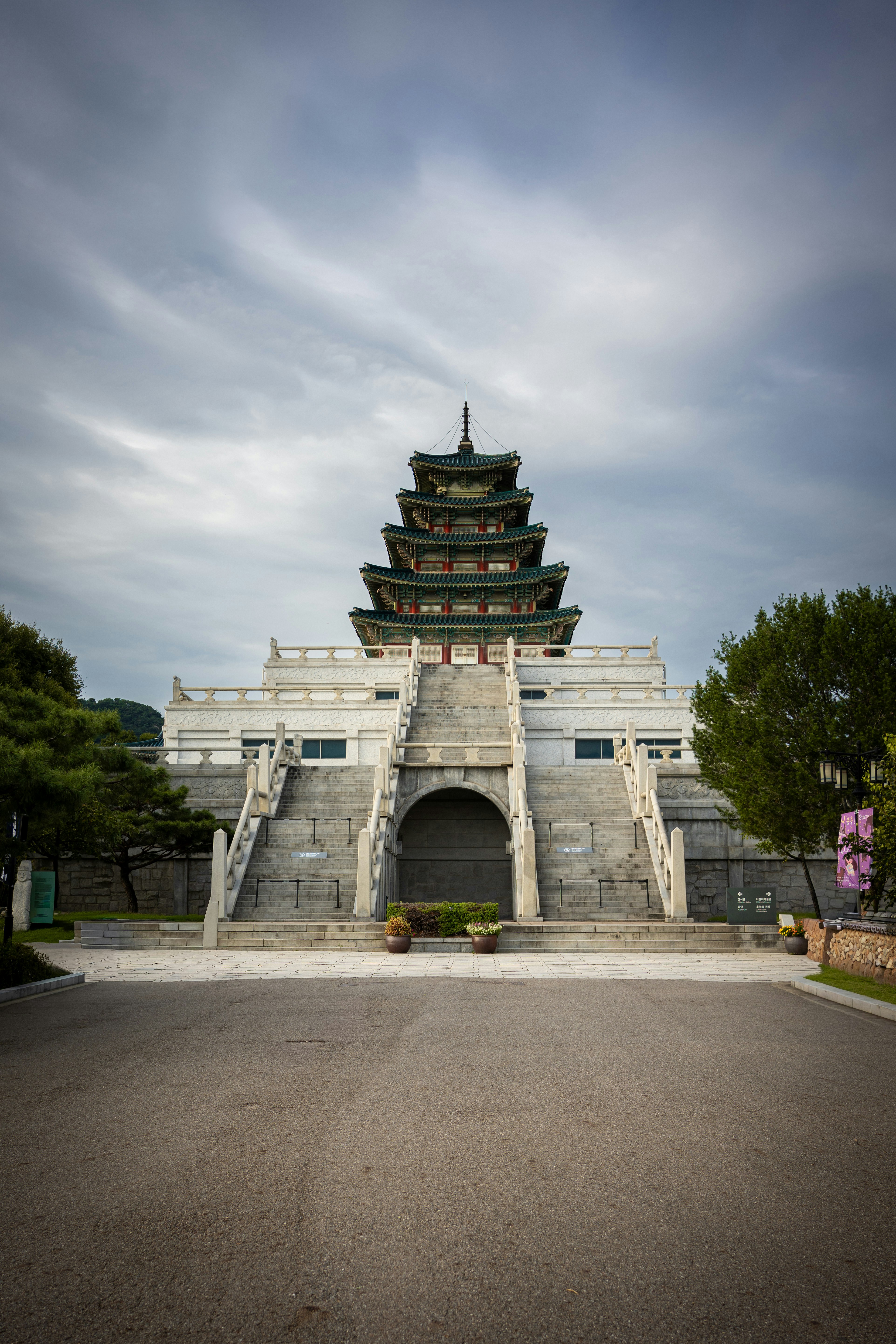 Traditional korean building with tiered roof under clouds