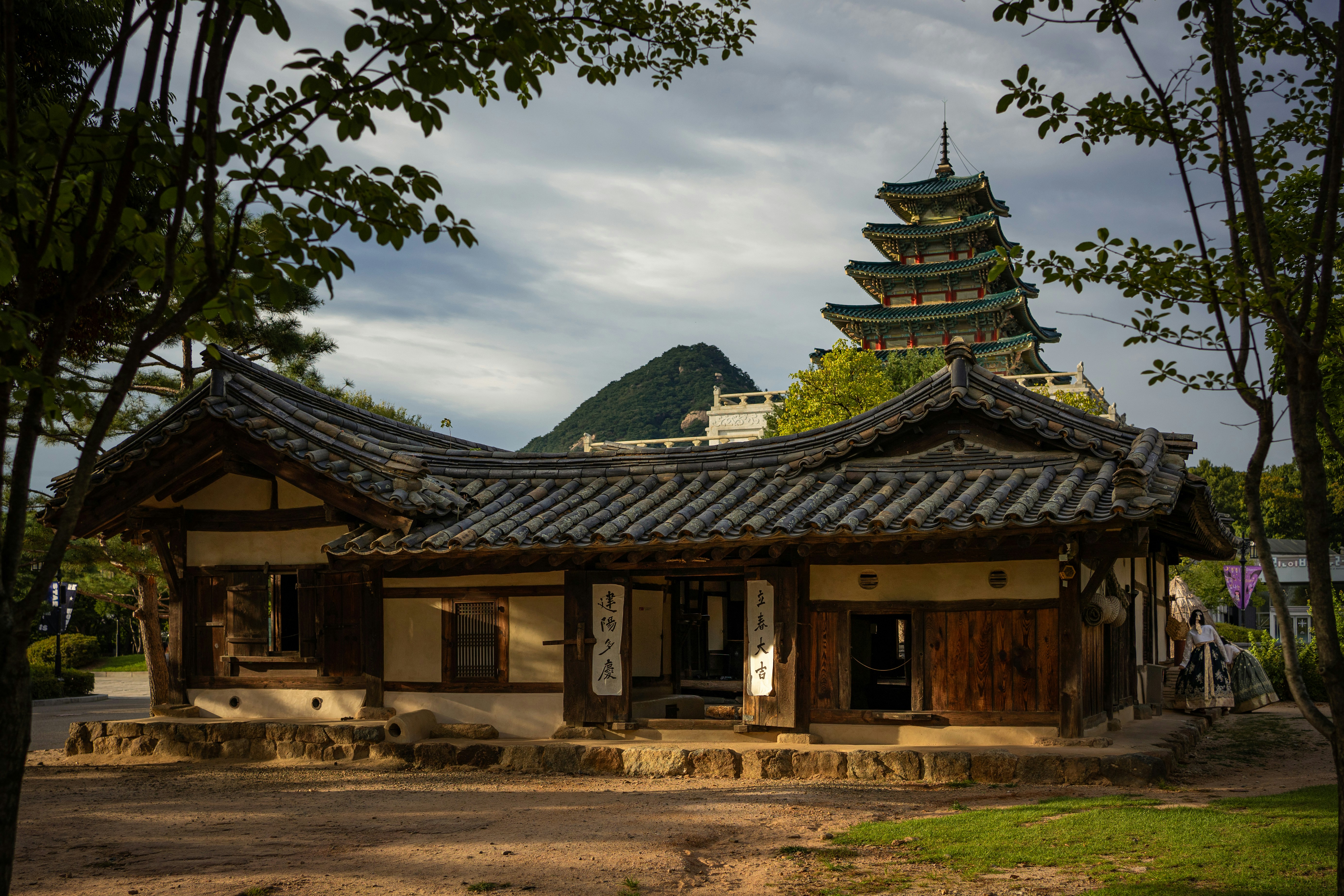 Traditional korean houses with a pagoda in the background.