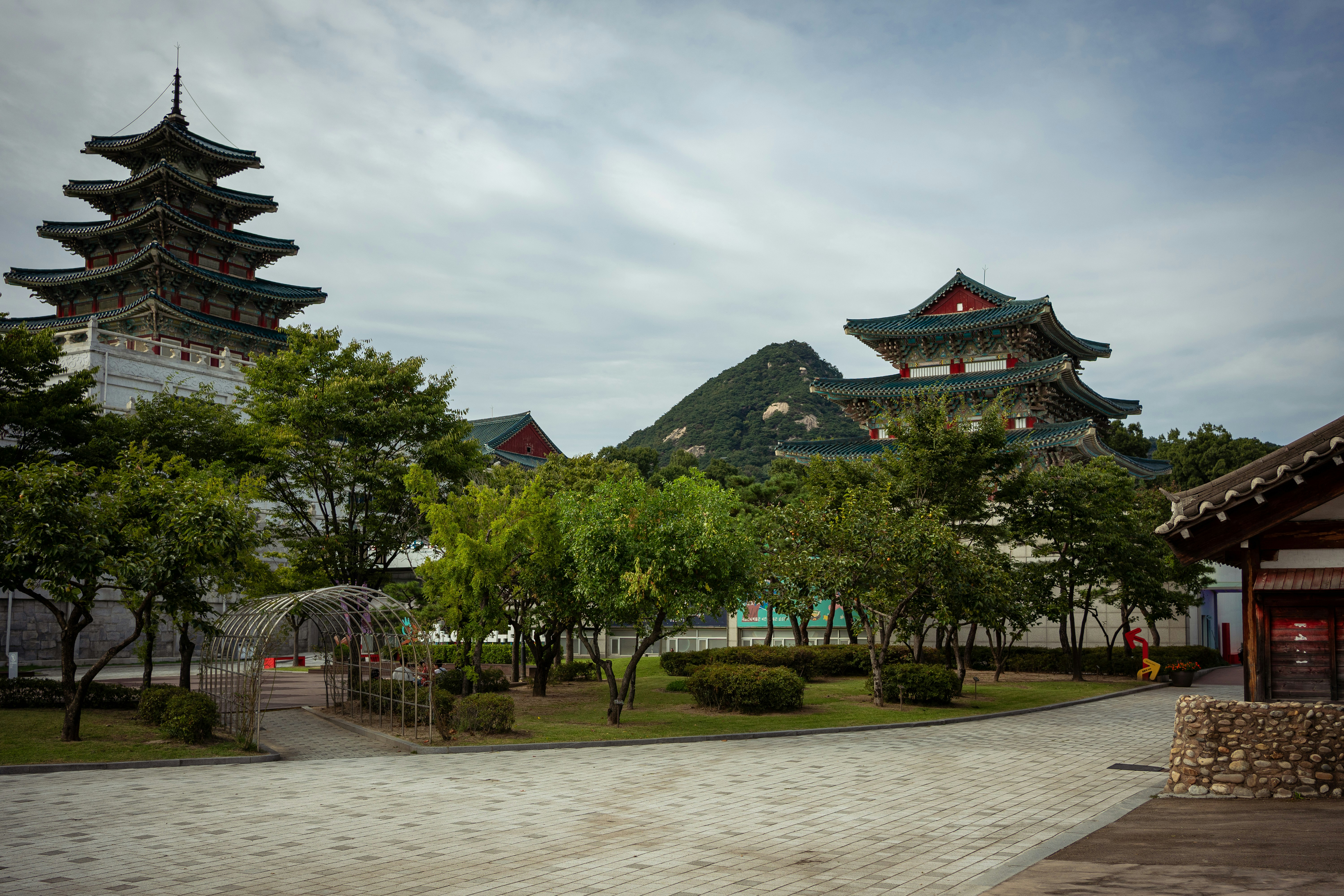 Traditional korean buildings with pagodas and trees.