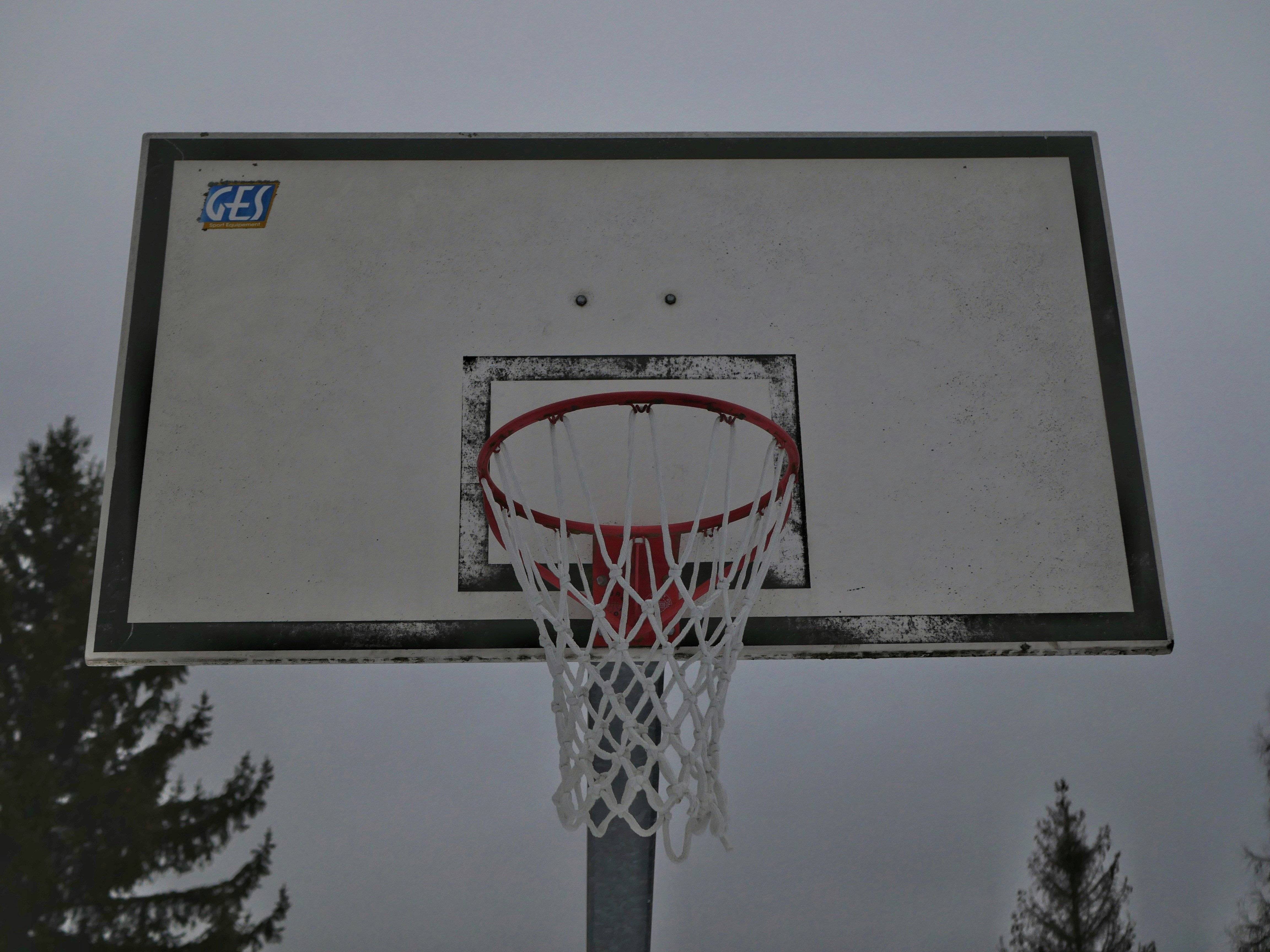 Basketball hoop and backboard on a cloudy day